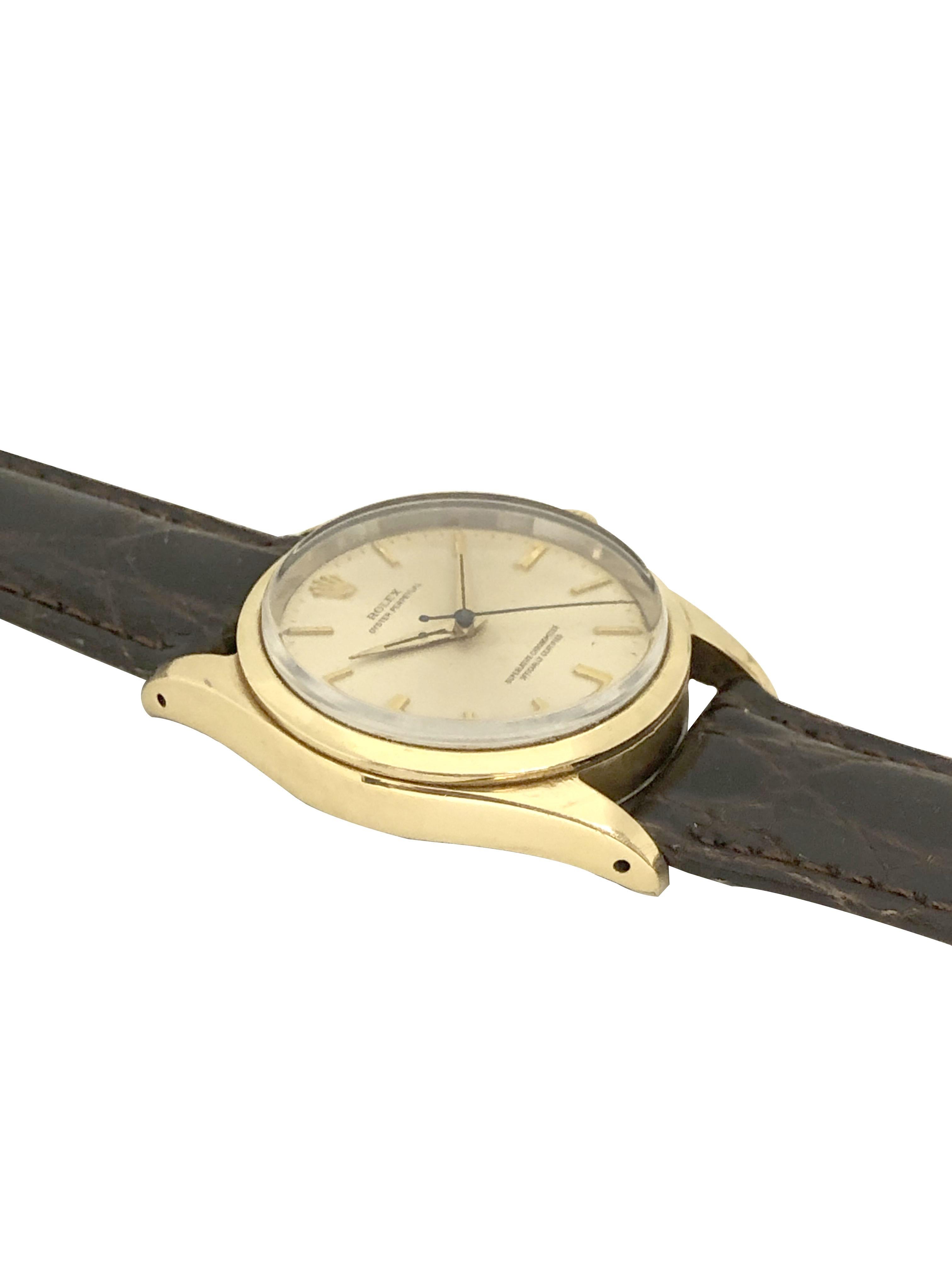 Circa 1980 Rolex Oyster Perpetual Reference 1014 Wrist Watch, 34 M.M. Yellow Gold Shell case with Stainless Steel Oyster back, Caliber 1130 Automatic Self Winding Movement. Silver Satin Dial with Raised Baton Markers and a sweep seconds Hand,