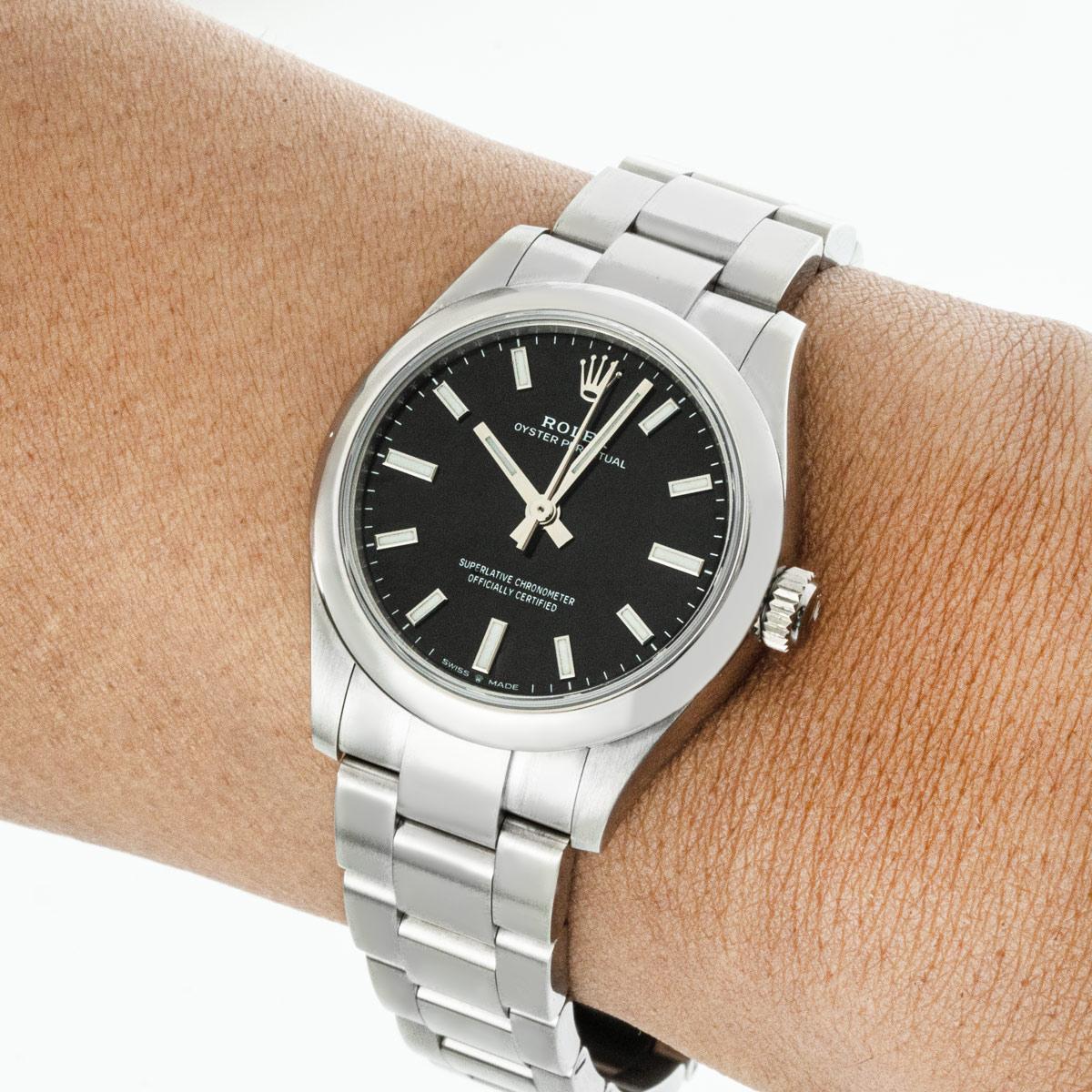 An Oyster Perpetual 31 in Oystersteel from Rolex. Features a black dial with applied hour markers and a smooth fixed bezel. The Oyster bracelet comes with the folding Oysterclasp. Fitted with a scratch-resistant sapphire crystal and a self-winding