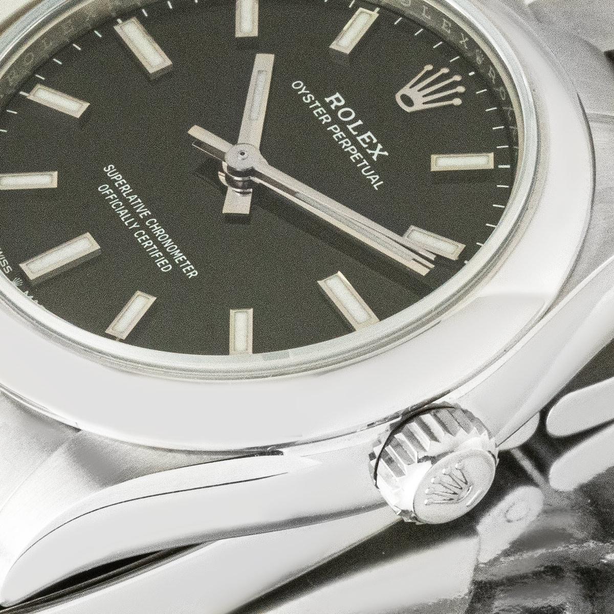 Una Oyster Perpetual 31 de acero Oystersteel de Rolex. Presenta una esfera negra con índices aplicados y un bisel fijo liso. El brazalete Oyster viene con el cierre desplegable Oysterclasp. Equipado con un cristal de zafiro resistente a los arañazos