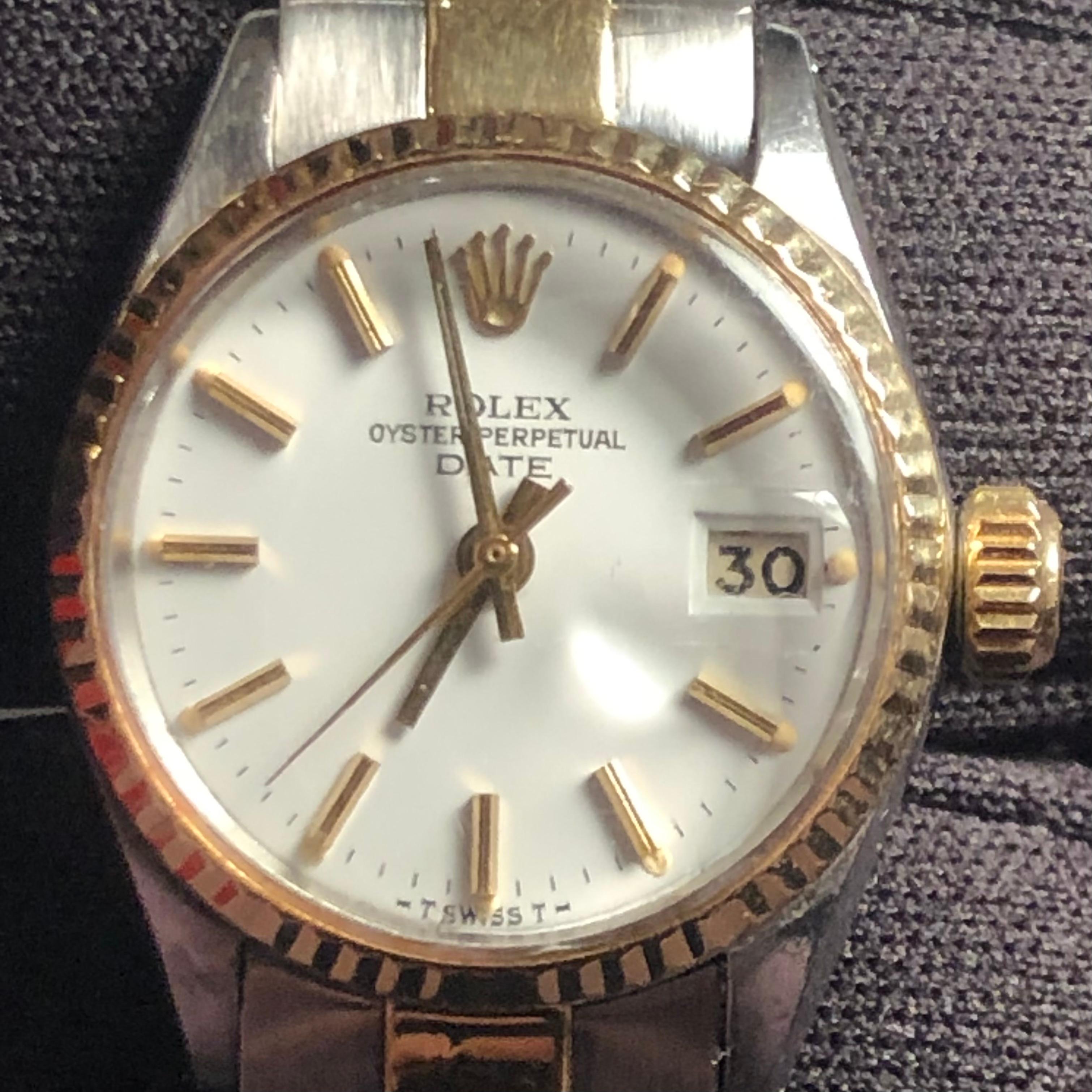 Rolex Oyster Perpetual 6517 two tone 14k Lady Date 26mm white dial ladies watch. The Rolex movement is running and it's an official self-winding Rolex automatic movement.

This original genuine Rolex timepiece features a 14k yellow gold fluted bezel