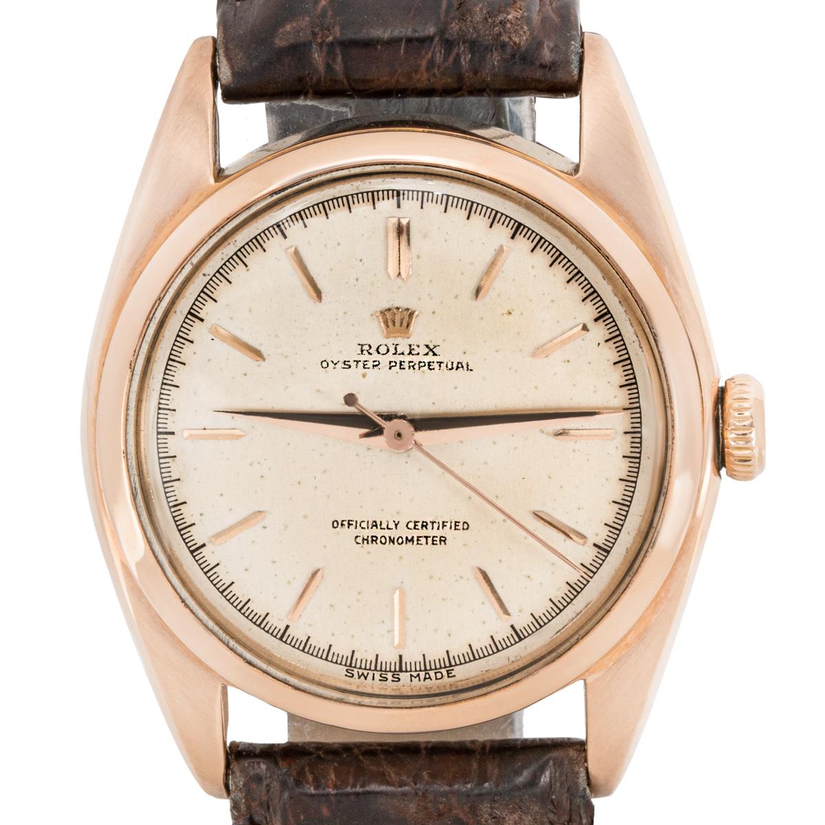 An 18k Rose Gold Oyster Perpetual Bubbleback Vintage Gents Wristwatch, original silver dial with applied hour markers, a fixed 18k rose gold bezel, a brown leather strap with a gold plated pin buckle (both not by Rolex), plastic glass, automatic