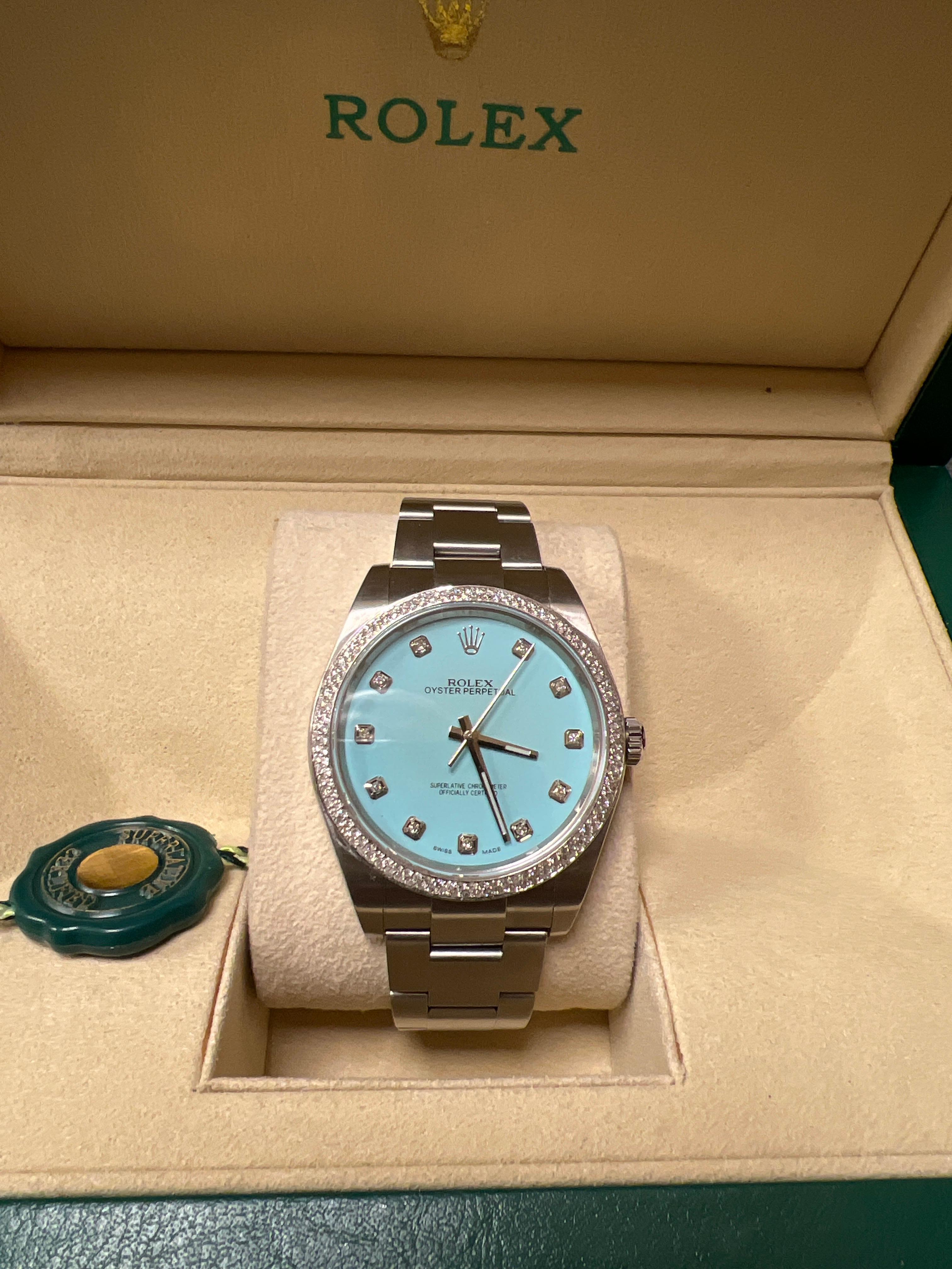 Rolex Oyster Perpetual stainless steel customized aftermarket custom turquoise colored diamond dial and diamond bezel offered by Alex & Co. This stunning timepiece is pre-owned in excellent condition and features a custom Tiffany style dial with