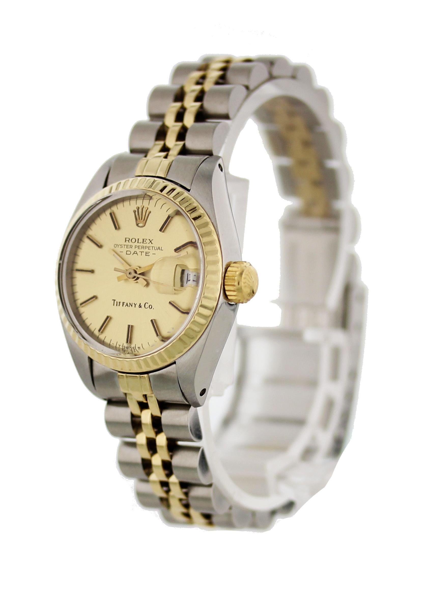 Ladies Rolex Oyster Perpetual Date 6917. 26 mm stainless steel case. 18k yellow gold fluted bezel. Champagne Tiffany dial with yellow gold hands and markers. 18k yellow gold and stainless steel Jubilee band with a stainless steel fold-over clasp