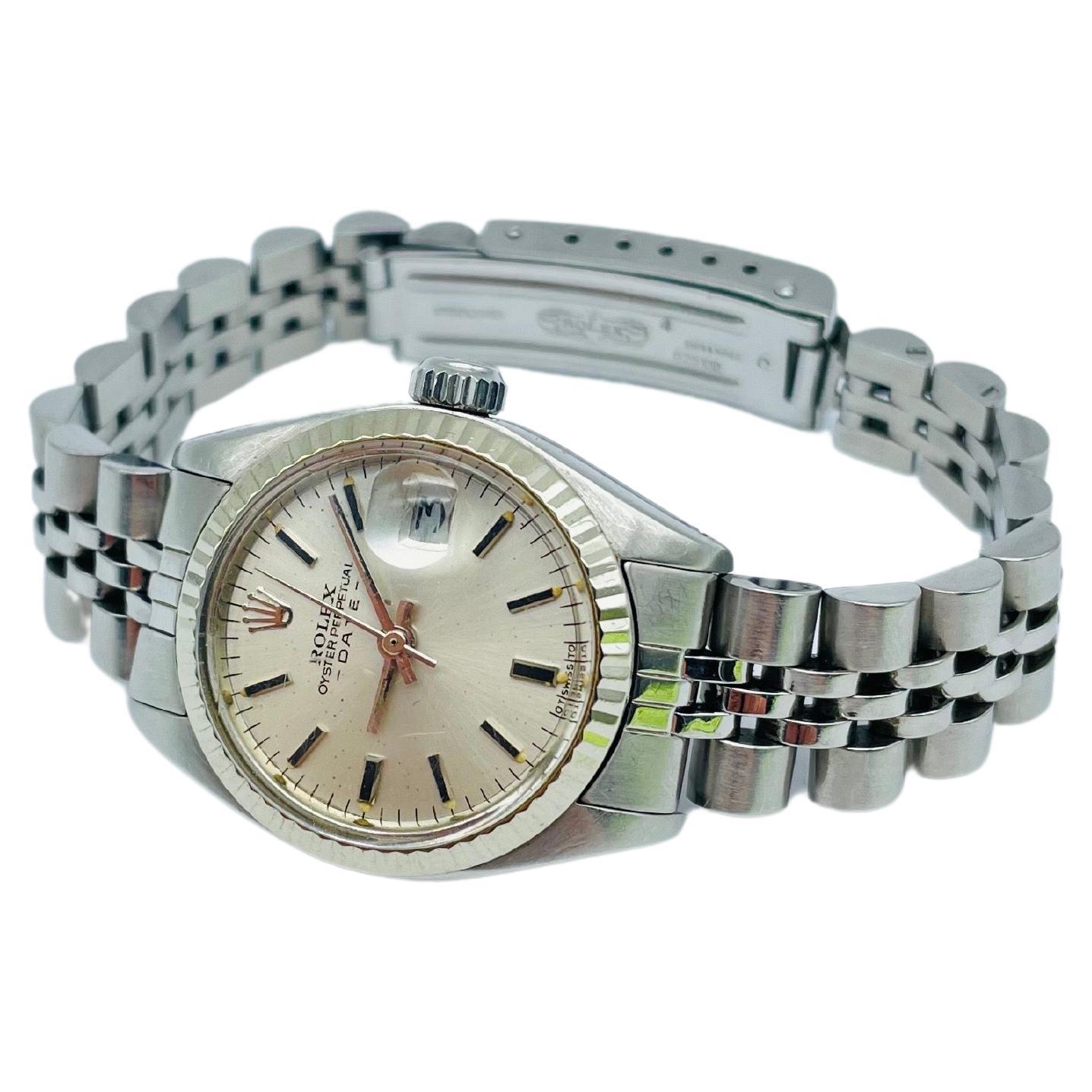 Allow me to paint a picture of elegance and sophistication for you, with the stunning ROLEX Oyster Perpetual Date Lady watch, reference 6917, crafted in 1977. The case is crafted from premium stainless steel, lending a sleek and modern touch to the