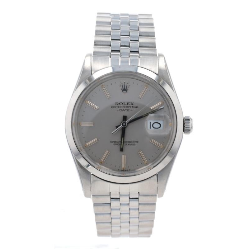 Brand: Rolex 
Model: Oyster Perpetual Date 
Model Number: 15000
Dial Color: Grey 
Year: 1982
Metal Content: Stainless Steel
Movement: Swiss Automatic 
Number of Jewels: 27
Warranty: One-Year

Case Width (not including the crown): 34mm
Band Width: