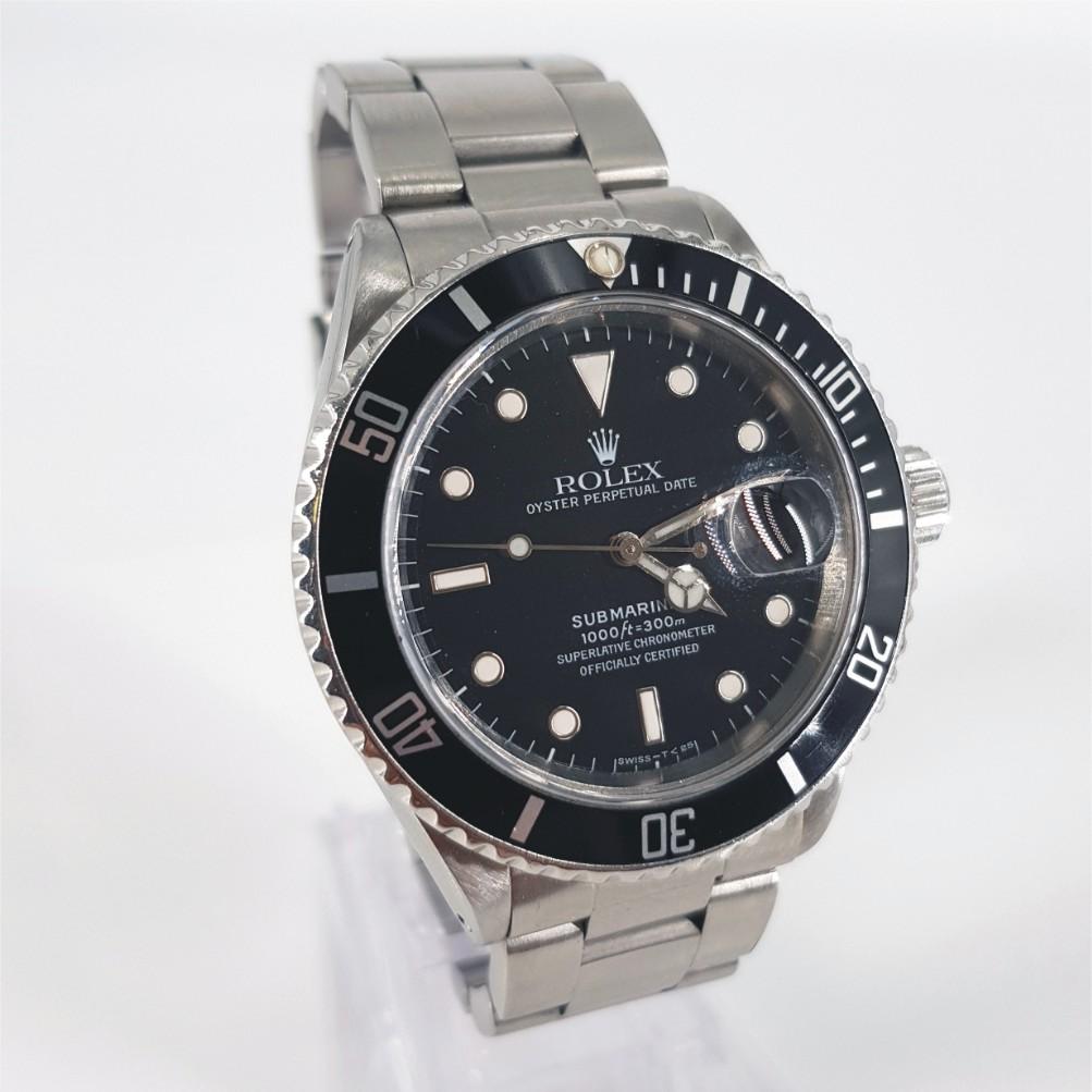 Rolex Oyster Perpetual Date Submariner Watch - Automatic in Very Good condition. 
Serial Number: R830207 
Year: 1988
Stainless Steel Case measuring 36mm with a Black Dial & Stainless Steel Strap measuring 60mm with Extra links
