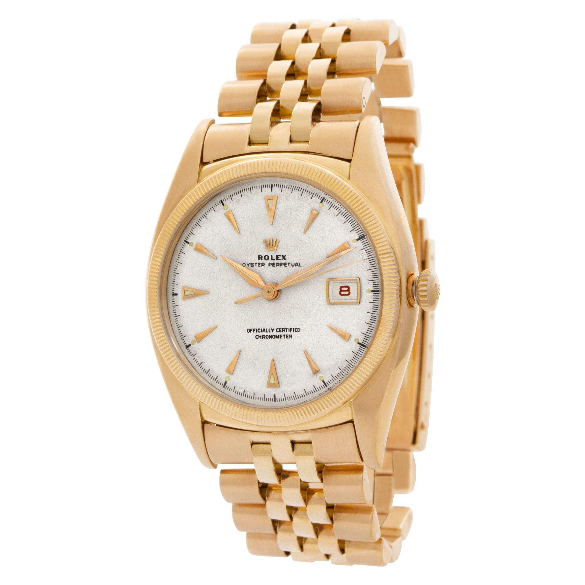Vintage Rolex Oyster Perpetual in 18k rose gold on a Jubilee bracelet. Dial is repainted. Off white dial with dagger style gold hands and hour markers. Date in red. Band dated jan, 1953.Automatic movement with date and sweep seconds. Ref 6105. Circa