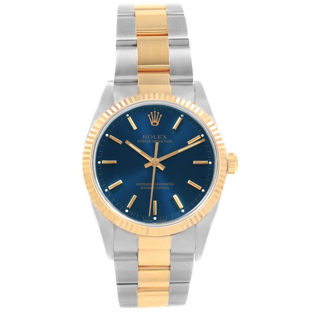 Rolex Oyster Perpetual Steel Yellow Gold Blue Dial Mens Watch 14233. Officially certified chronometer self-winding movement. Stainless steel and 18K yellow gold oyster case 34.0 mm in diameter. Rolex logo on a crown. 18K yellow gold fluted bezel.
