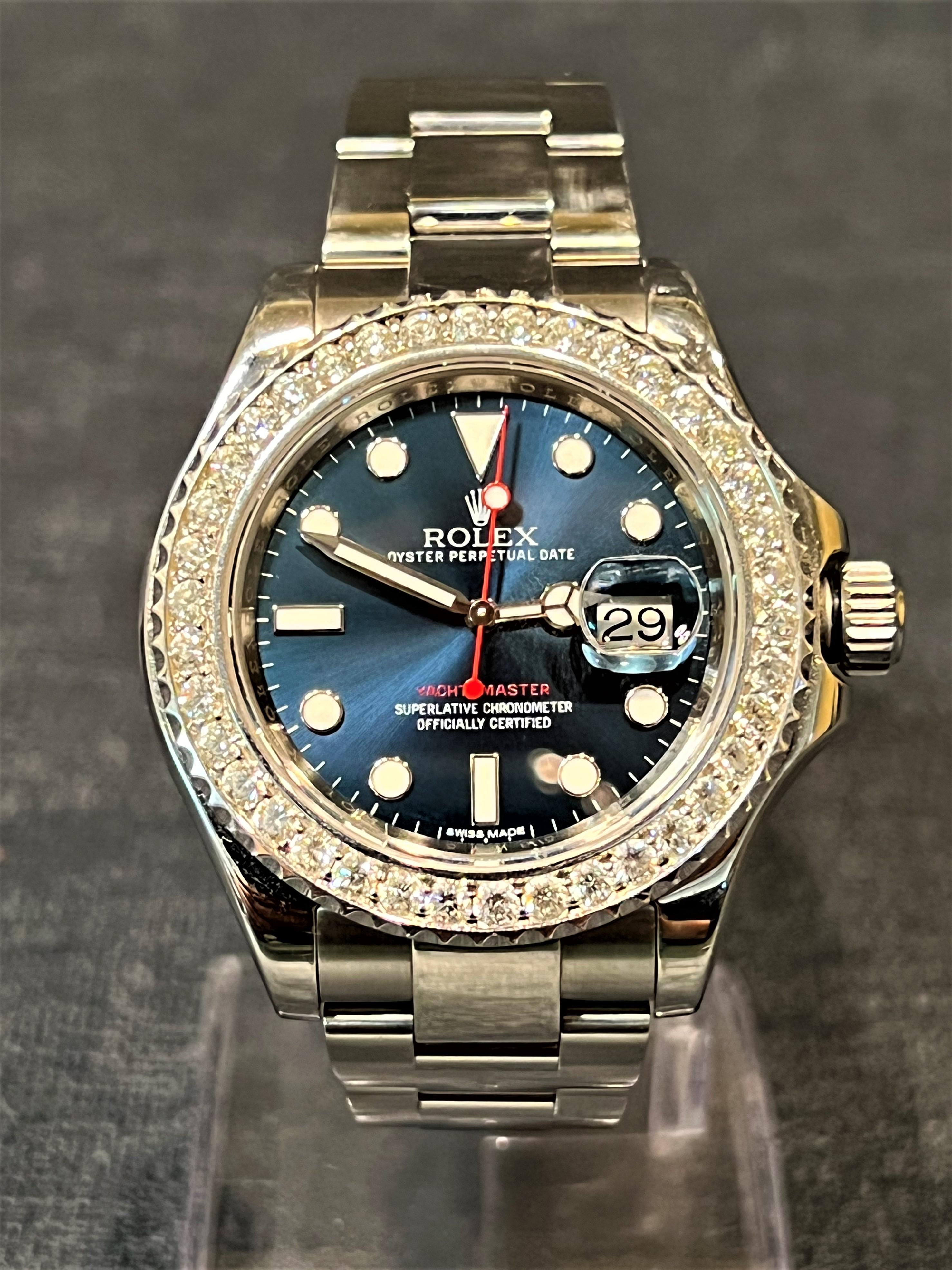 A contemporary styled Oyster Perpetual Yacht-Master wristwatch by Rolex with a 2.56 carat diamond bezel and a Blue index dial with Superluminova. Includes original box with papers and Swimpruf tag, Red Seal and a Superlative chronometer Officially