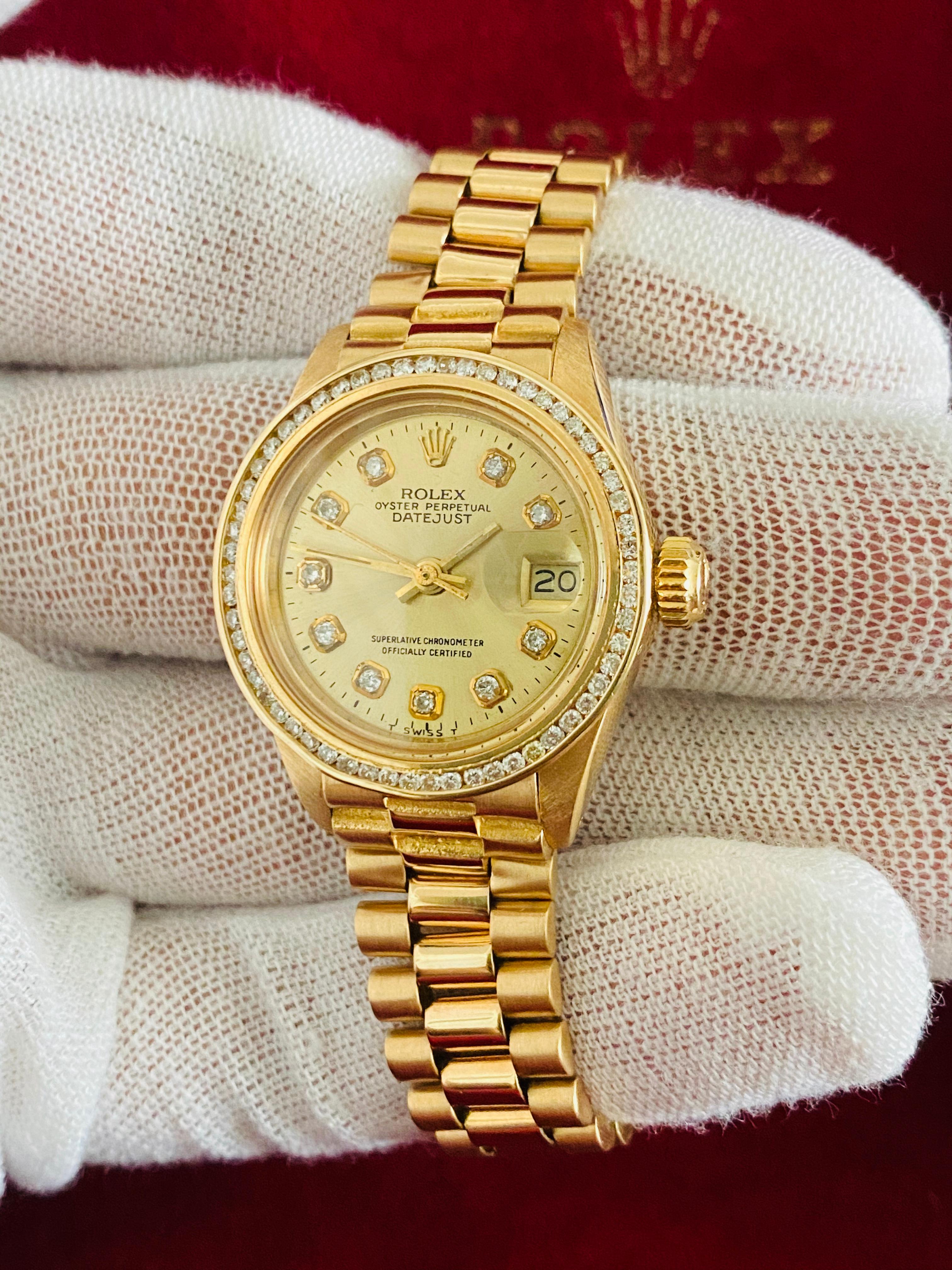 Brand: Rolex
Model: Oyster Prepetual Datejust. 6917
Metal: 18K yellow gold 
Diameter: 26mm 
Movement: Automatic
Custom diamond diamond and diamond bezel
1.20 carat diamonds total. SI clarity, G-H color. Bezel diamonds set in channel setting. 
Comes