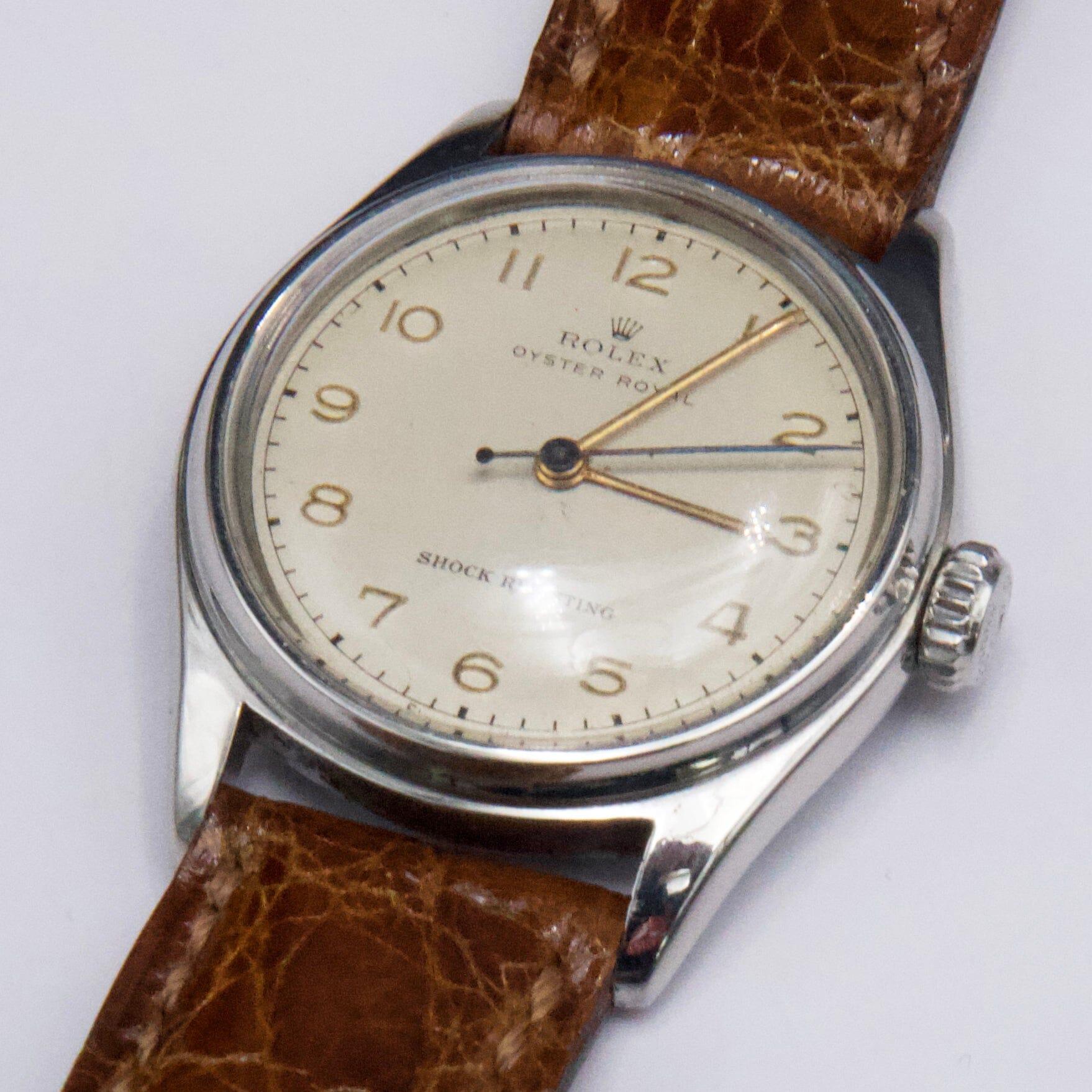 Reloj Rolex Oyster Royal 4444 para caballero. Caja de acero inoxidable de 31 mm. Bisel liso de acero inoxidable. Esfera plateada con agujas doradas e indicador de hora con números arábigos. Correa posventa de cuero marrón con hebilla. Se ajusta a