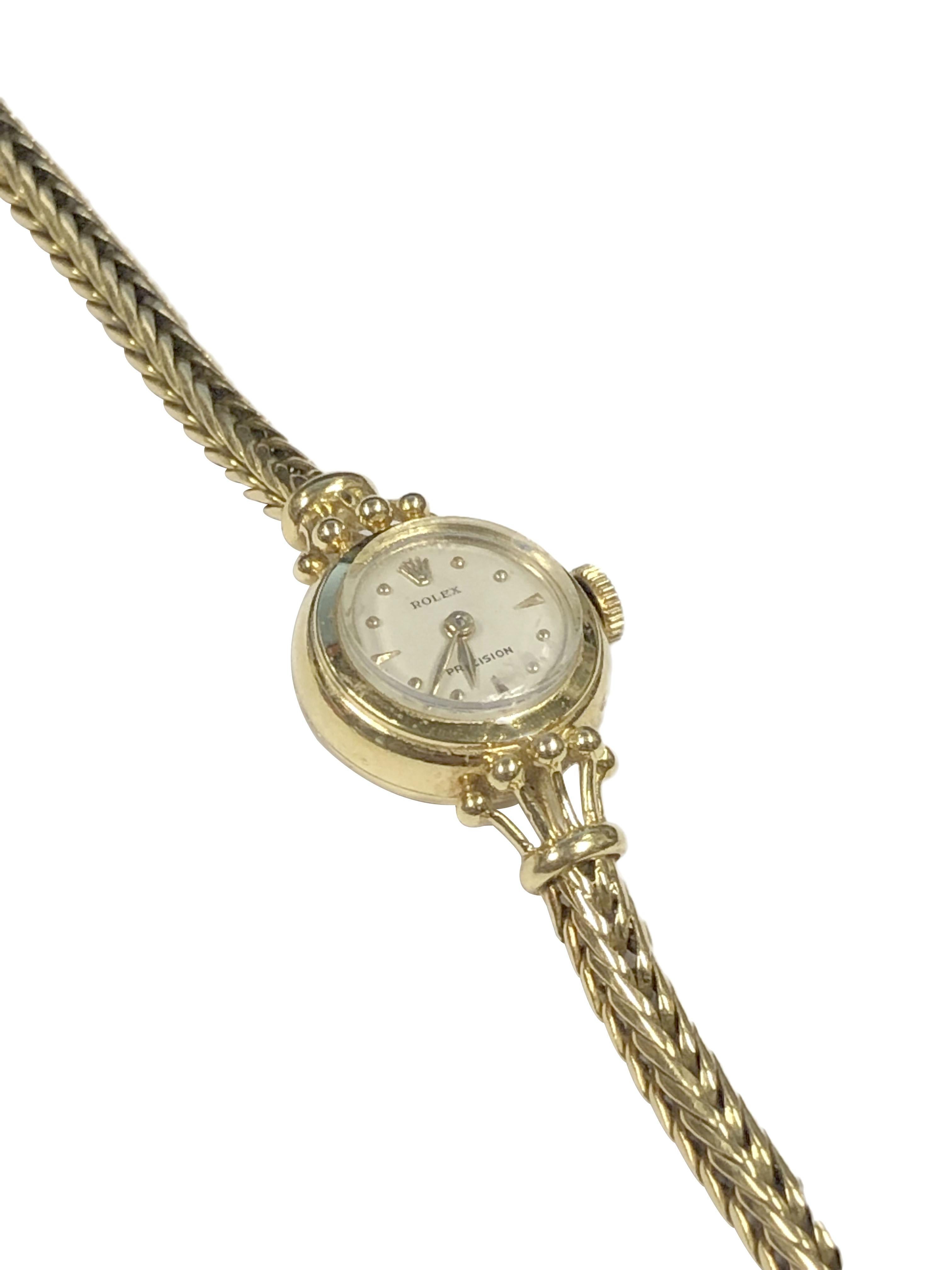 Circa 1940s Rolex Ladies Precision Wrist Watch, 16 M.M. Diameter X 5 M.M. thick 14k Yellow Gold 2 Piece case, 17 Jewel mechanical, manual wind nickle lever movement. Original mint condition White dial with raised Gold markers, Rolex logo crown.