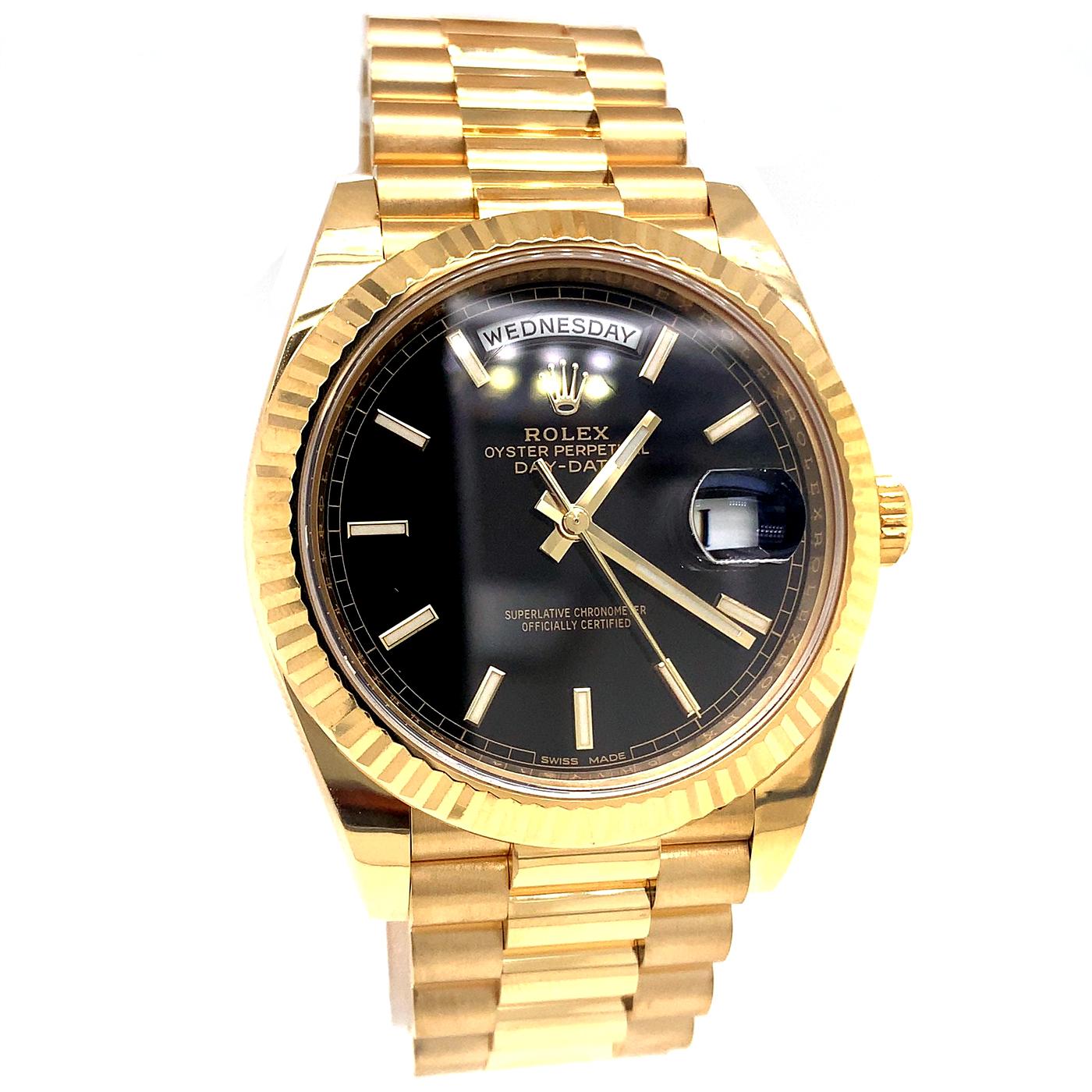 The Oyster Perpetual Day-Date 40 in 18 ct yellow gold with a Black dial, fluted bezel, and a President bracelet. The Day-Date was the first watch to indicate the day of the week spelled out in full when it was first presented in 1956. The Rolex