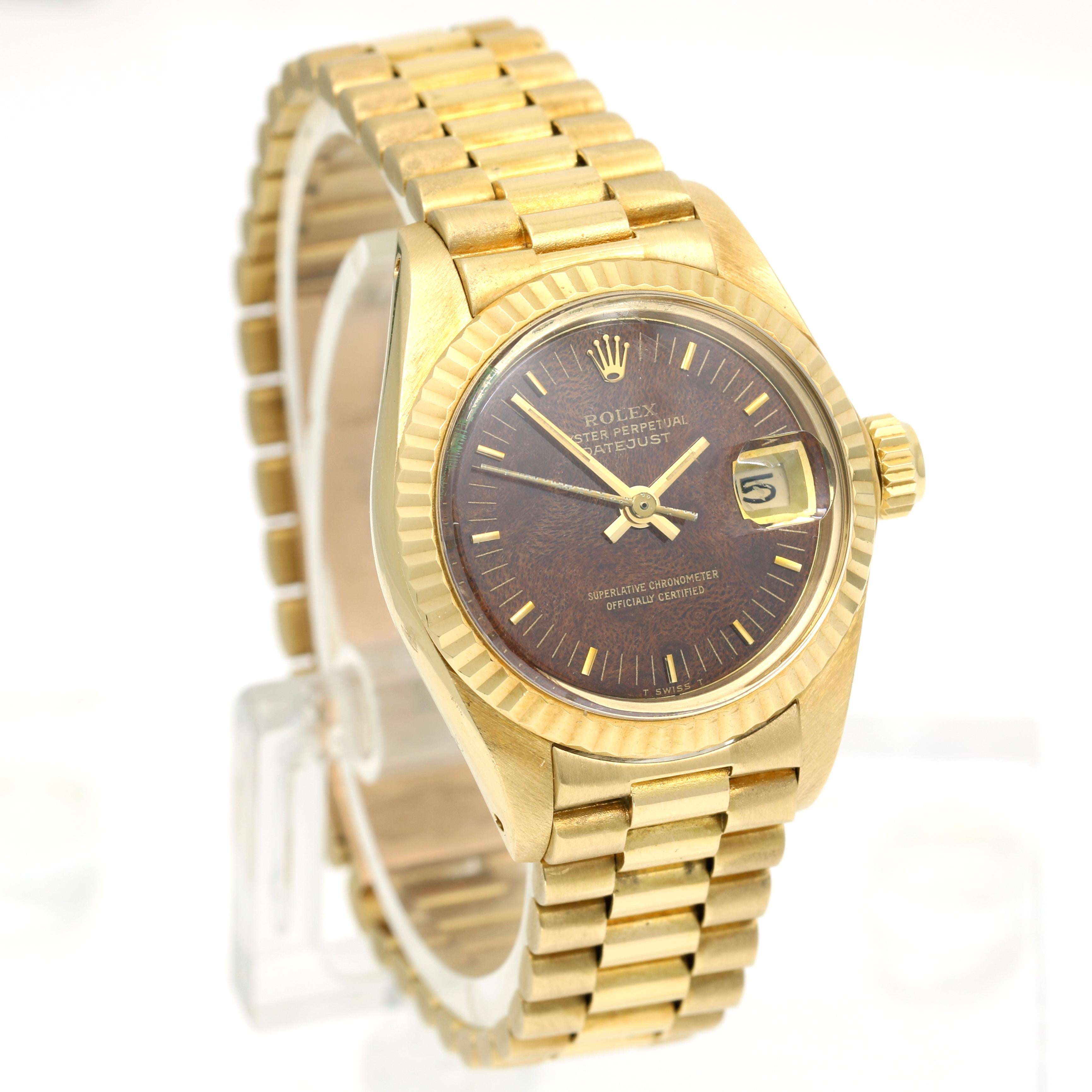 Immerse yourself in luxury with the exquisite Rolex President Lady Datejust 6917. Crafted from lustrous 18k yellow gold, this 26mm timepiece boasts a rare mahogany wood brown dial that exudes elegance and rarity. In excellent condition and having