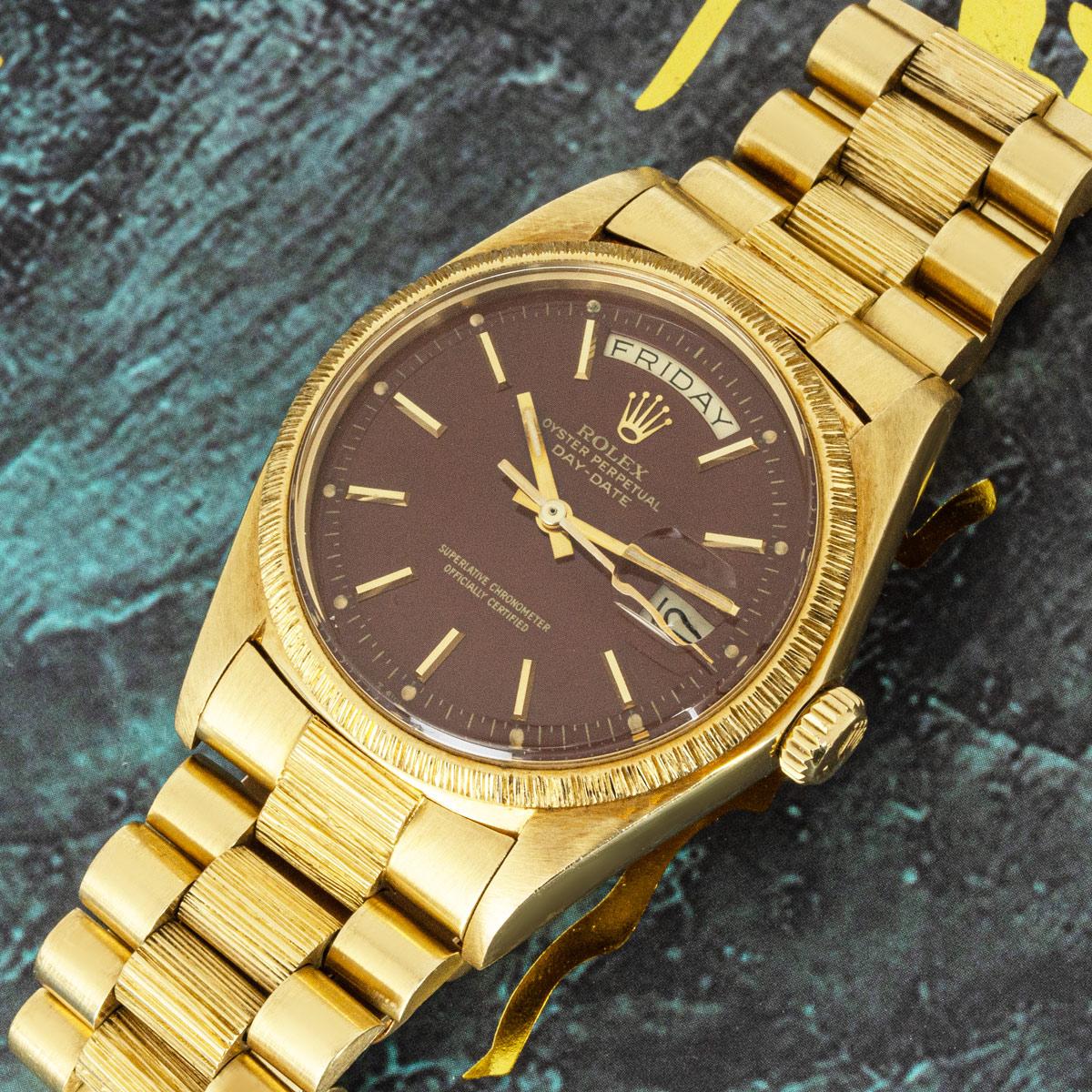 A rare yellow gold Day-Date by Rolex. Featuring the highly collectable Oxblood Stella dial which is complemented by a fixed Bark Finish yellow gold bezel.

The piece is fitted with plastic glass, a self-winding automatic movement, and a yellow gold