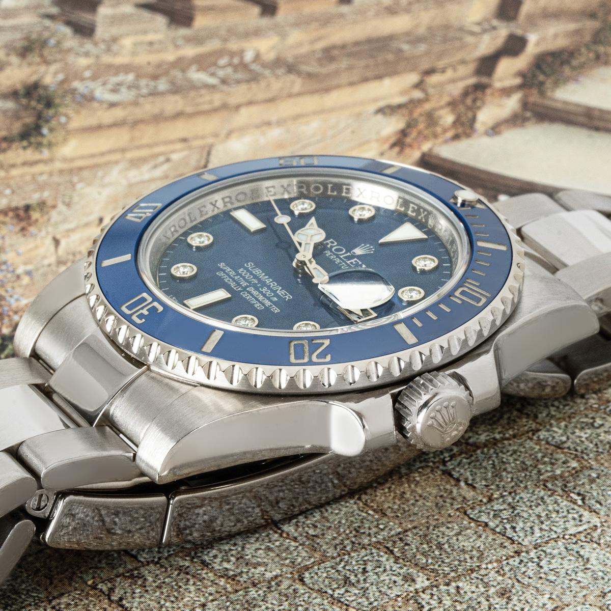 Une Submariner Date Smurf en or blanc de 40 mm de Rolex. Elle présente un rare cadran bleu avec des index sertis de diamants, complété par une lunette tournante unidirectionnelle en céramique bleue avec des graduations de 60 minutes. Le bracelet