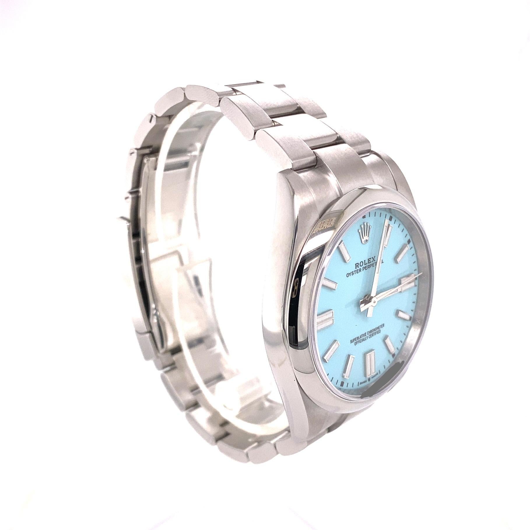 This stainless steel 41mm Oyster Perpetual by Rolex features a turquoise blue dial with smooth bezel.  It is an oyster bracelet with fold clasp, sapphire crystal face, 3230 movement, and a screw down crown.  It is water resistant up to 100 meters. 