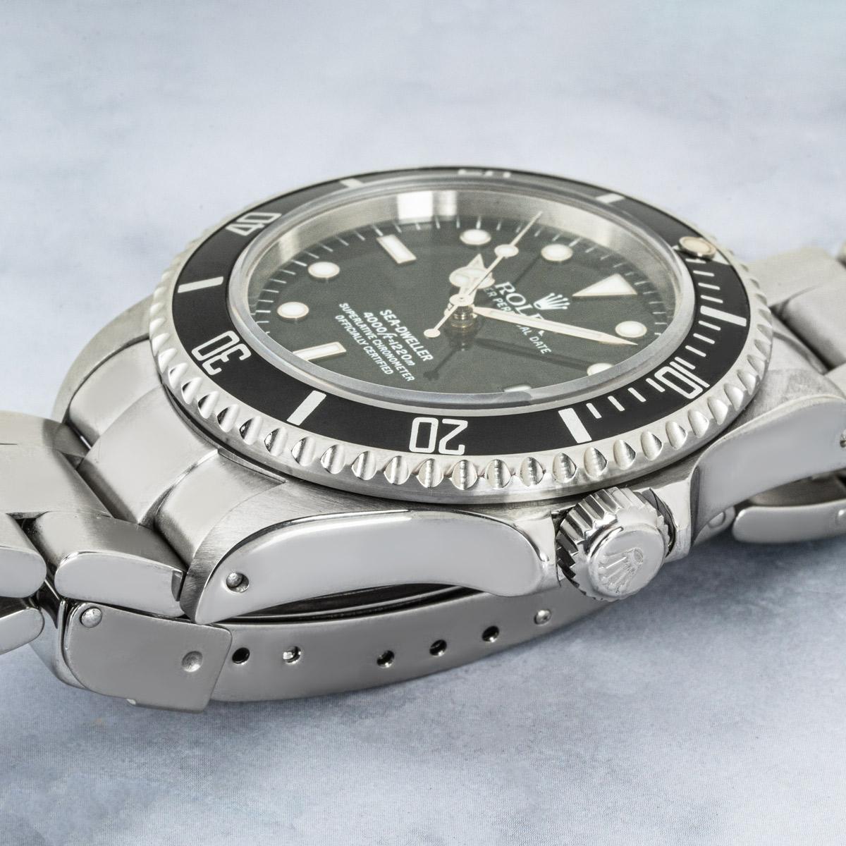 Eine 40 mm große Sea-Dweller aus Stahl von Rolex. Sie verfügt über ein schwarzes Zifferblatt mit applizierten Stundenmarkierungen, eine Datumsanzeige und eine schwarze, einseitig drehbare Lünette mit 60-Minuten-Teilung.

Ausgestattet mit einem