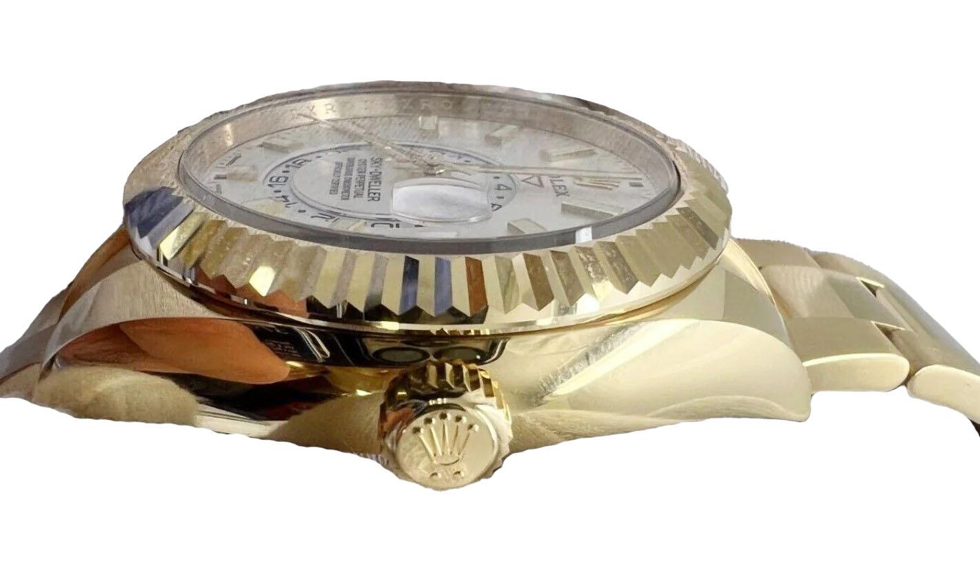 Découvrez le summum du luxe et de l'innovation avec la montre Rolex Sky-Dweller 42 mm cannelée en or jaune 18 carats, un garde-temps remarquable conçu pour le voyageur exigeant. Ce modèle Rolex extraordinaire allie harmonieusement l'excellence