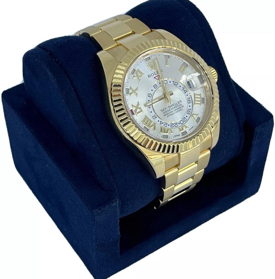 Bold, brilliant, and built for the modern traveler, the Rolex Sky-Dweller Ref. 326938 is a striking blend of innovation and luxury. Crafted in solid 18K yellow gold, this 42mm timepiece features a stunning Sundust dial—a refined, sunray-finished
