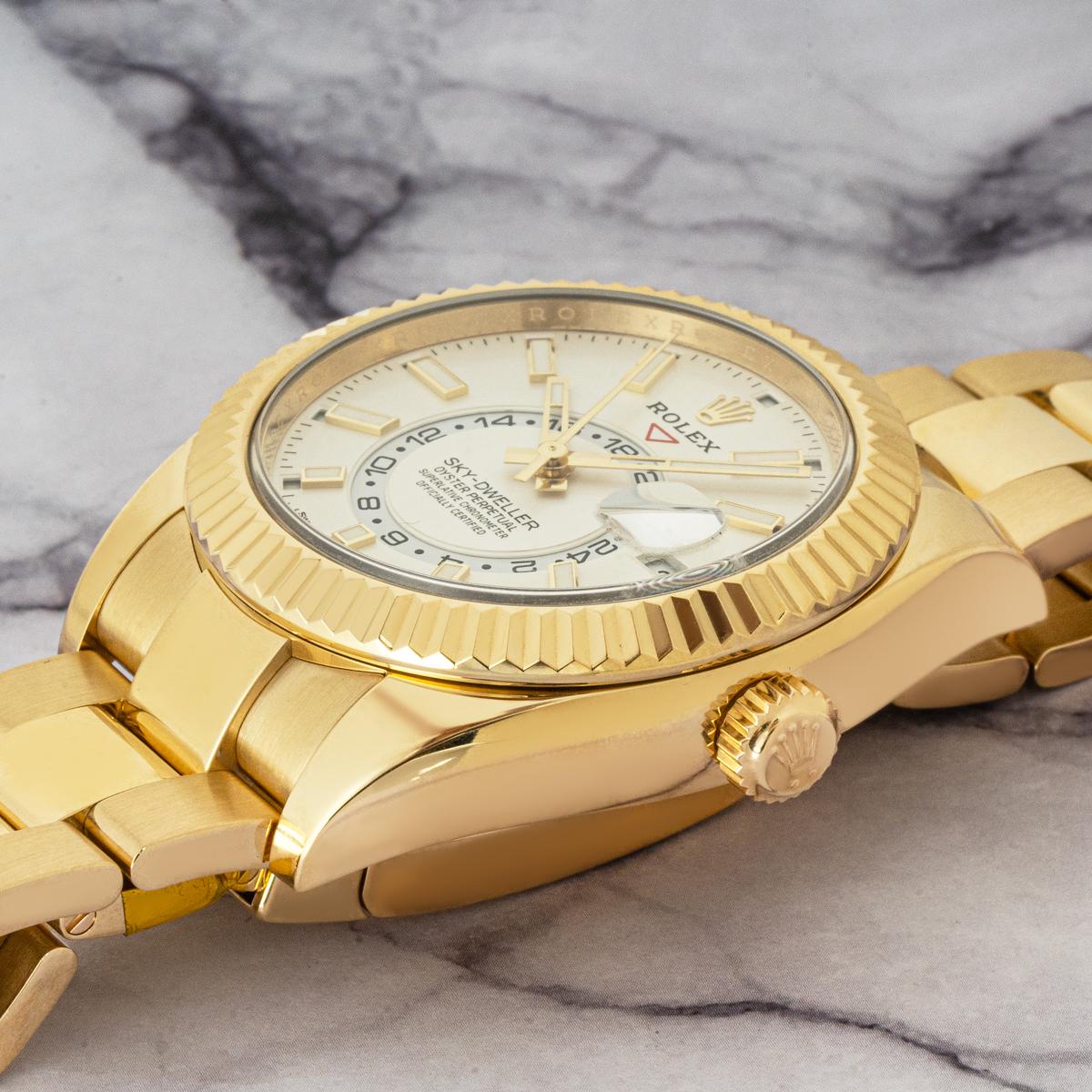 A yellow gold Sky-Dweller in yellow gold by Rolex. Featuring an intense white dial with the date, a month display via the 12 apertures, and a 24-hour display. The watch also features a second-time zone function, which can be set using the signature