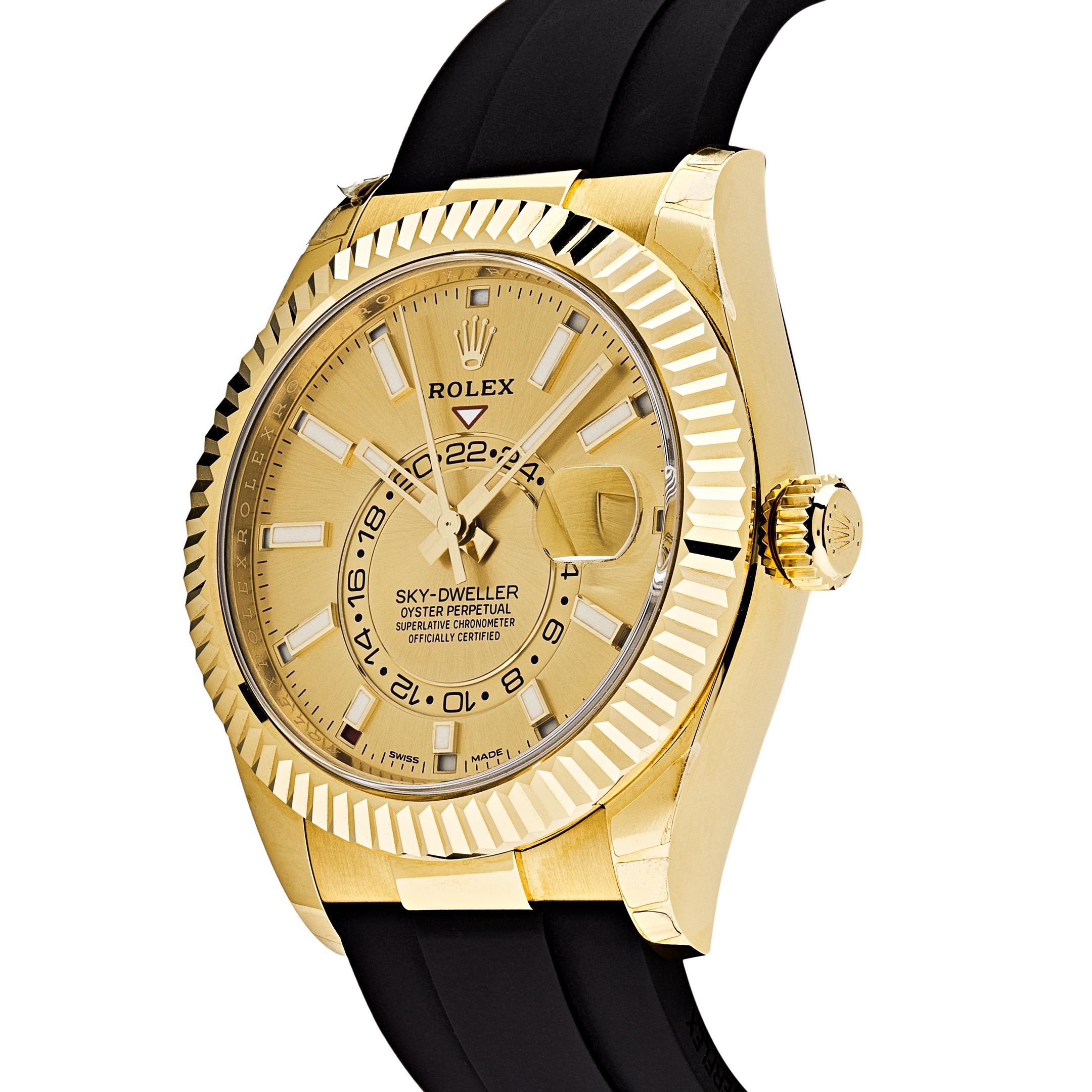 This Rolex Sky-Dweller features dual time zones, inlaid in a 42mm 18k yellow gold case and fluted bezel surrounding a champagne dial with luminous hour markers. The Ring Command bezel can be rotated to select the date, the local time and the