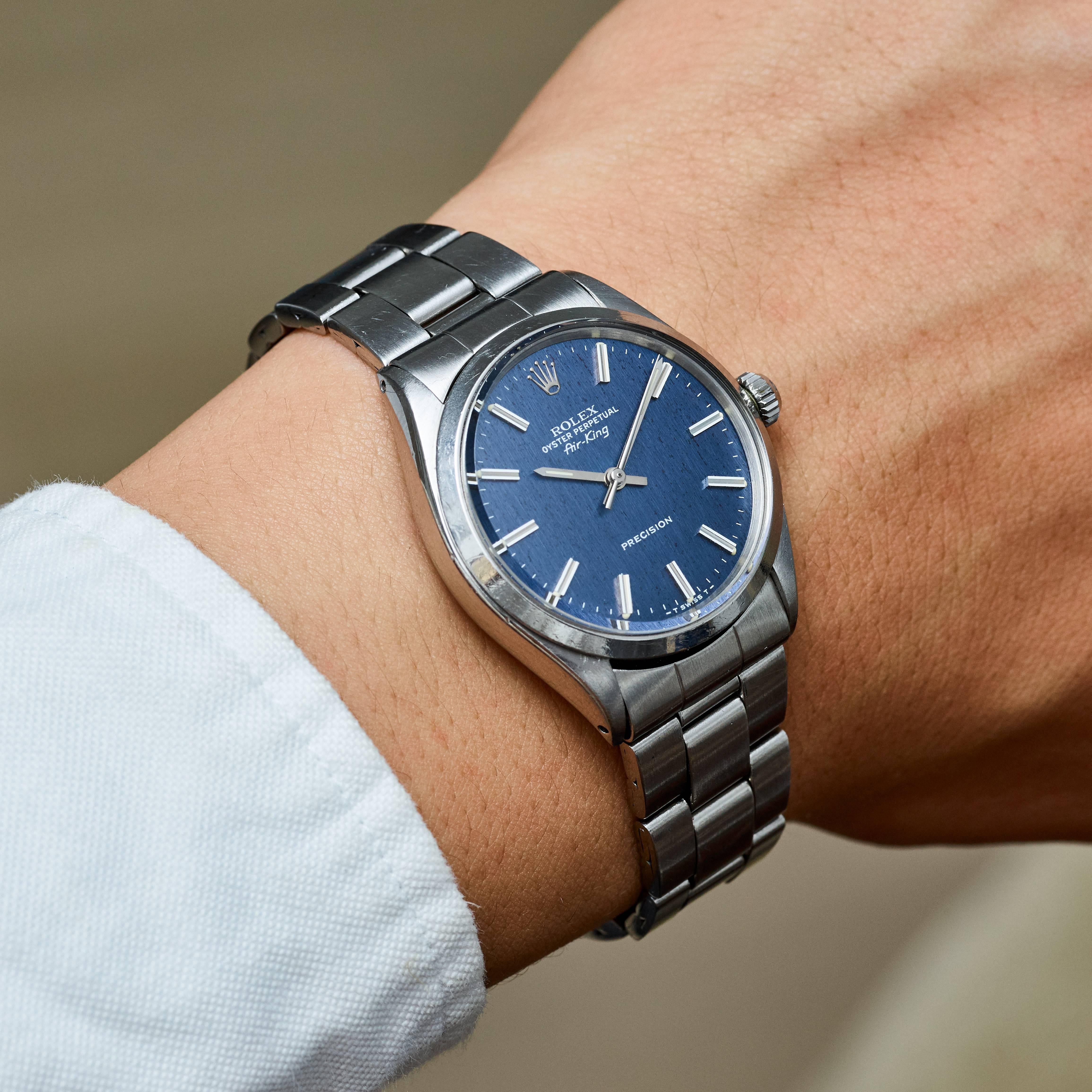 Rolex Stainless Steel Oyster Perpetual Air-King Stainless Steel Watch
Factory Blue Linen Dial with Wide Index Markers
Stainless Steel Smooth Bezel
Stainless Steel Case
34mm in size 
Features Rolex Automatic Movement 
Acrylic Crystal
From Early