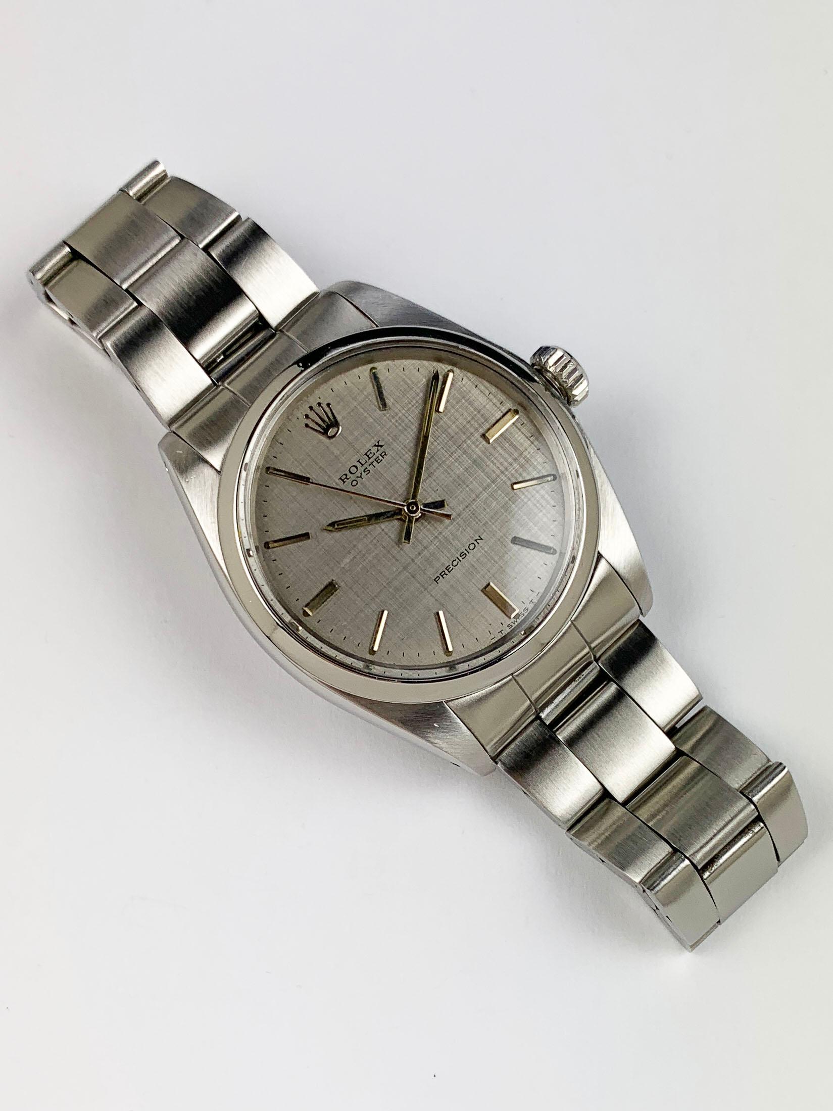 Rolex Stainless Steel Oyster Precision Manual Wind Watch
Factory Silvered Linen Dial with Applied Hour Markers
Stainless Steel Smooth Bezel
Stainless Steel Case
34mm in size 
Features Rolex Manual Wind/Hand Winding Movement 
Acrylic Crystal
From