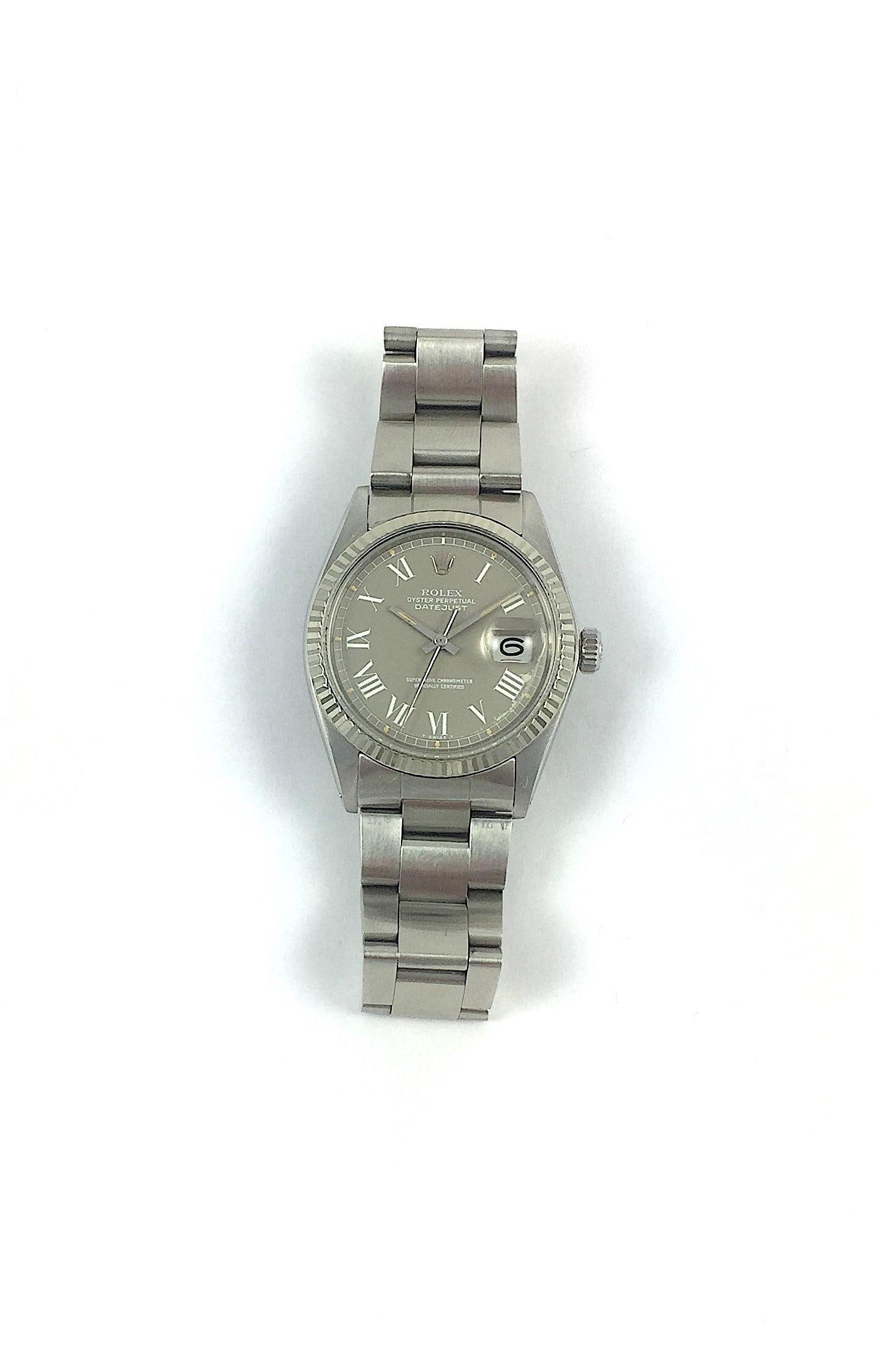 Rolex Stainless Steel and White Gold Oyster Perpetual Datejust Watch
Factory Rare Grey Buckley Dial with White Roman Numeral Hour Markers
Some Wear and Color Loss From Age on Dial
White Gold Fluted Bezel
Stainless Steel Case
36mm in size 
Features