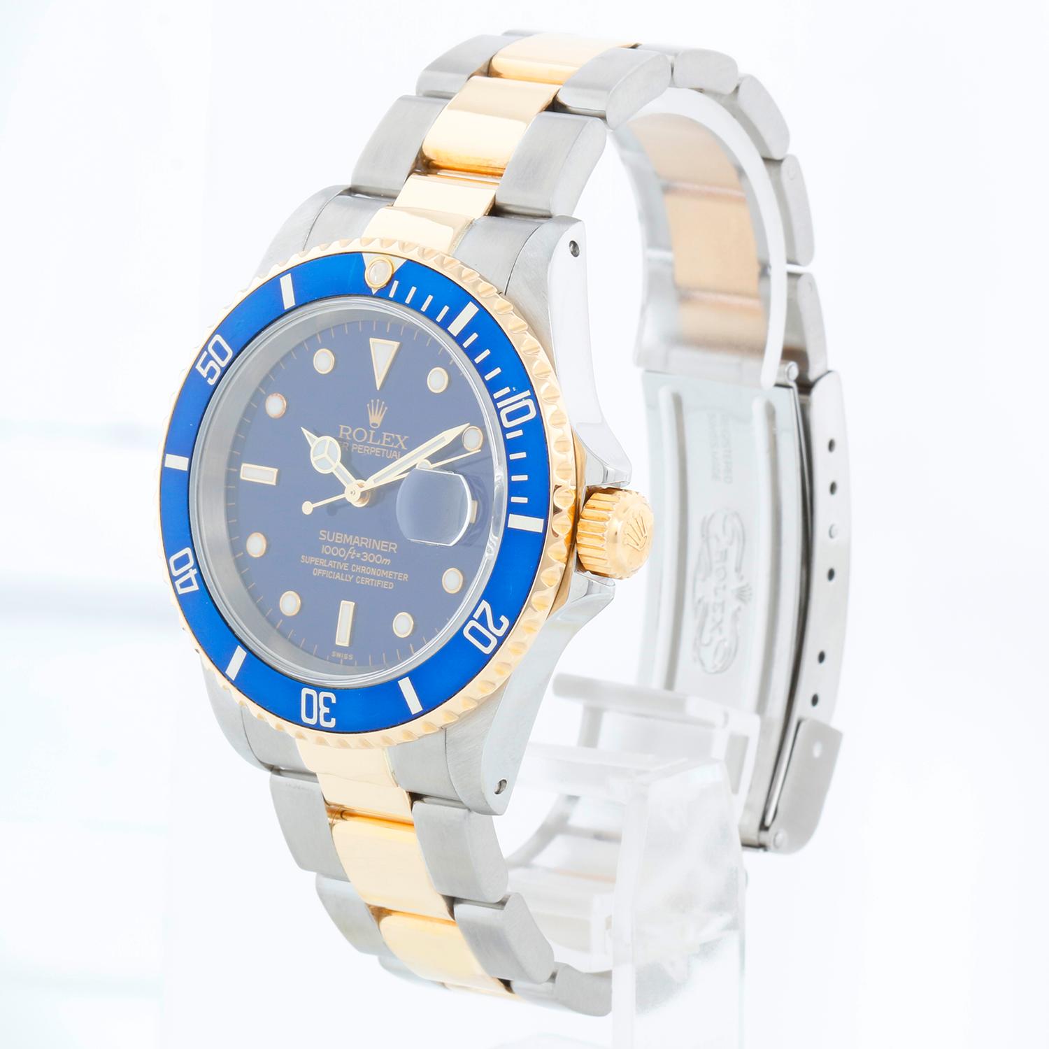 Rolex Submariner 2-Tone Steel & Gold Men's Watch 16613 - Remontage automatique, 31 rubis, étanche à la pression jusqu'à 1 000 pieds. Boîtier en acier inoxydable avec lunette en or jaune 18 carats . Cadran bleu avec index lumineux ; date à 3 heures.