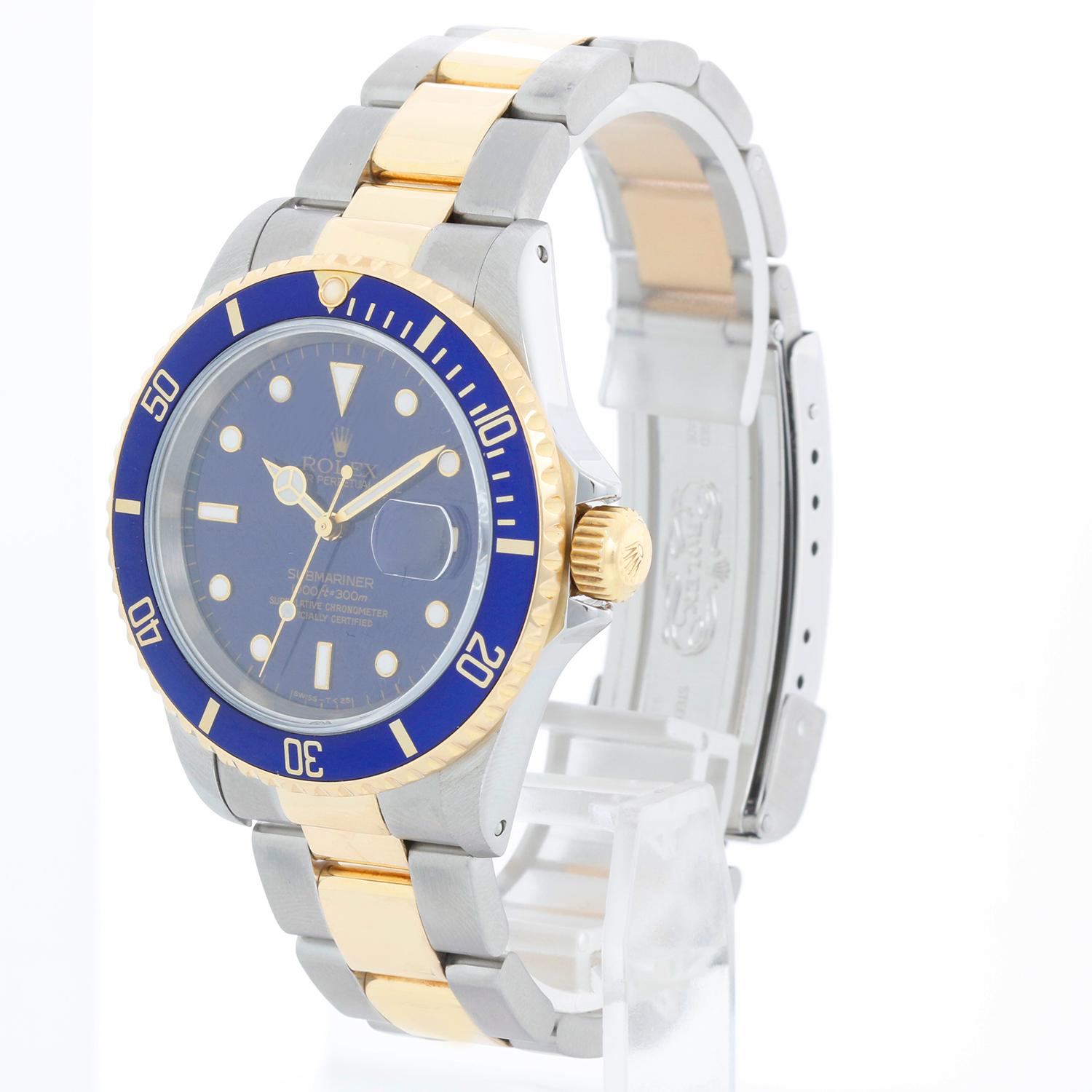 Rolex Submariner 2-Tone Steel & Gold Men's Watch 16613 - Remontage automatique, 31 rubis, étanche à la pression jusqu'à 1 000 pieds. Boîtier en acier inoxydable avec lunette en or jaune 18 carats . Cadran bleu avec index lumineux ; date à 3 heures.