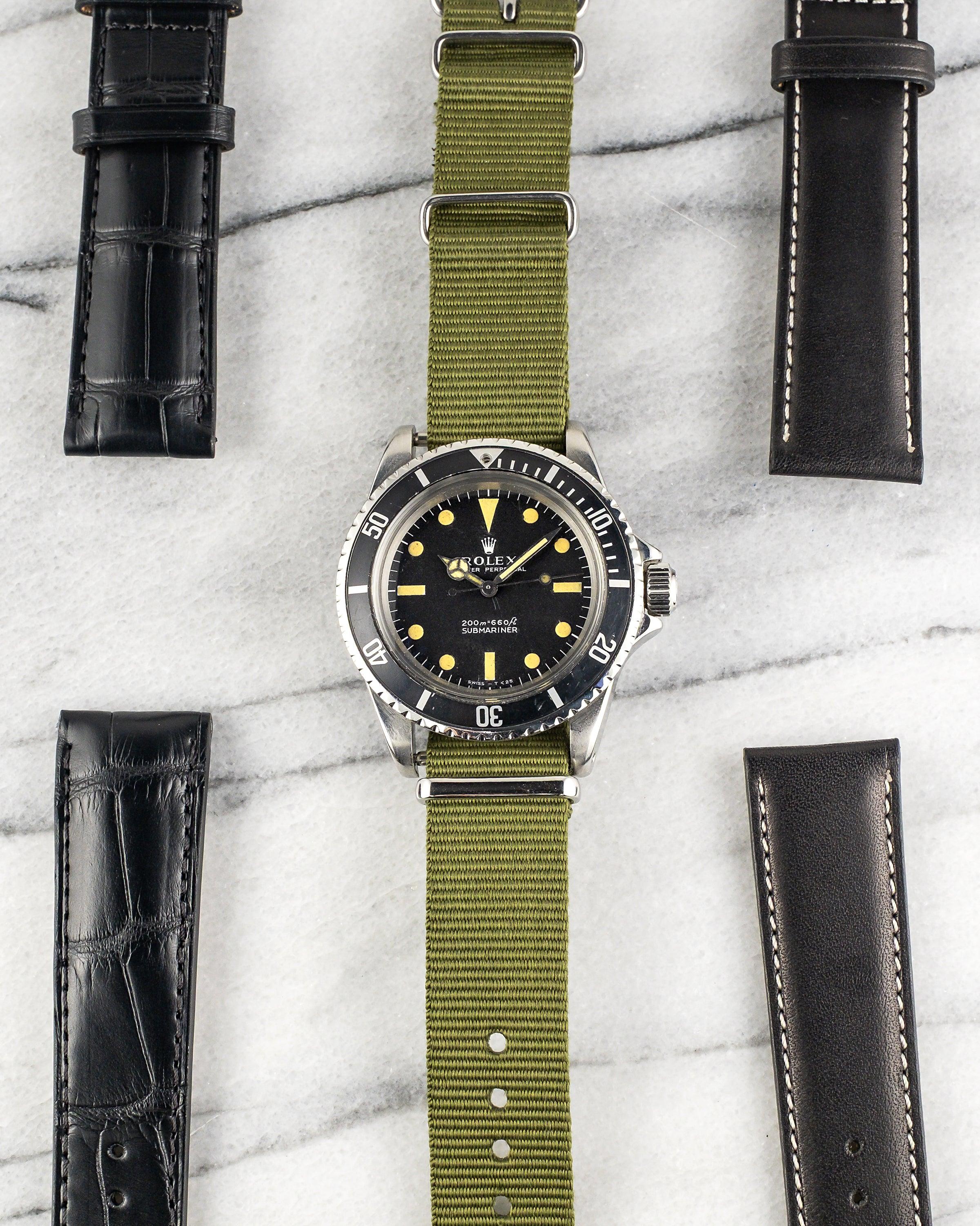 Here's a Rolex Submariner reference 5513 automatic with a matte black no date dial and tritium hour markers from the 1970s. Measurements include a 40mm steel case and 20mm lug width. The lume has aged to a uniform patina. The watch is fitted on a