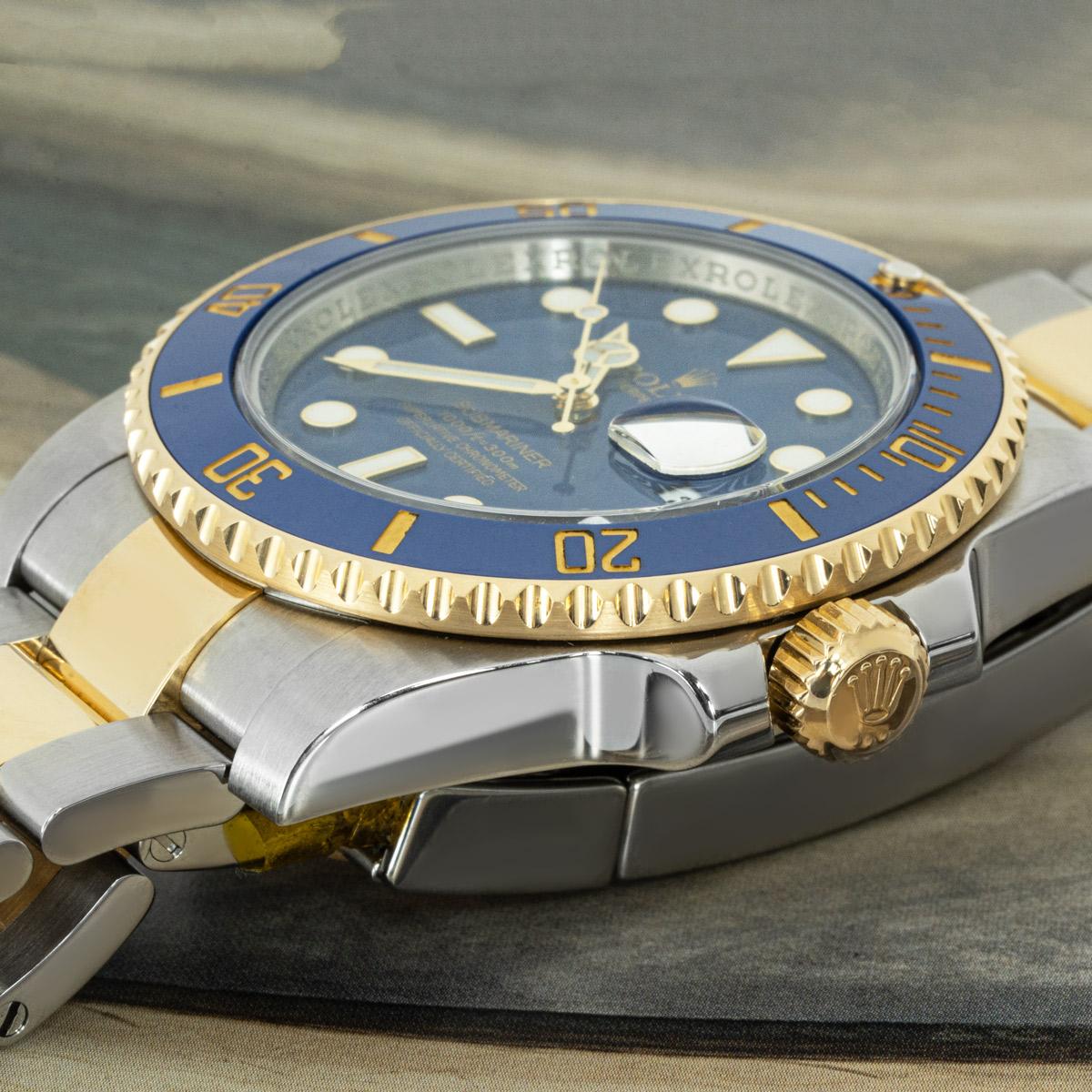 A 40mm Submariner Date in Oystersteel and yellow gold by Rolex. Featuring a blue dial with applied hour markers and a yellow gold uni-directional rotatable bezel which has a blue ceramic insert, with 60-minute graduations coated in gold.

Fitted