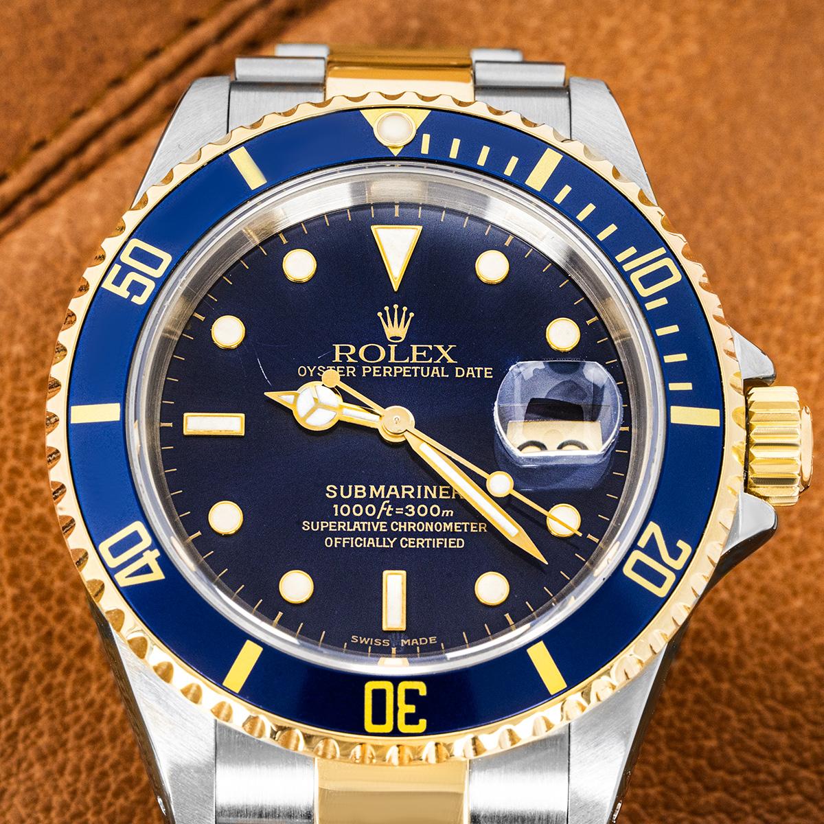 A mens 40mm steel and gold Submariner Date by Rolex. Features a blue dial with applied hour markers, a yellow gold uni-directional rotating bezel and a blue bezel insert. Fitted with a sapphire glass, a self-winding automatic movement and a
