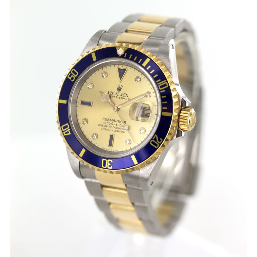 Rolex Submariner 40mm Two Tone Watch is circa 1994. The watch features a 40mm gold case, diamond number markers, with pinholes, factory diamond dial, blue bezel, gold and stainless steel Oyster band. The watch has been overhauled and serviced. One