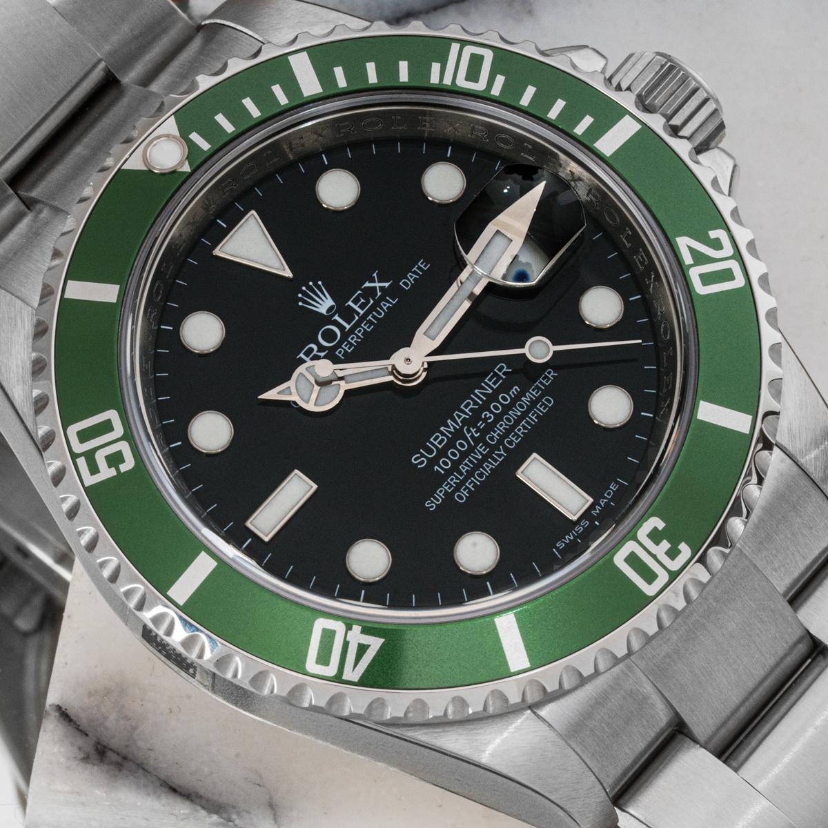 An unworn new old stock Submariner Date by Rolex in stainless steel, known as a Kermit. Features a black dial and a green bezel with 60-minute graduations.

The Oyster bracelet comes equipped with an Oysterlock deployant clasp. Fitted with a