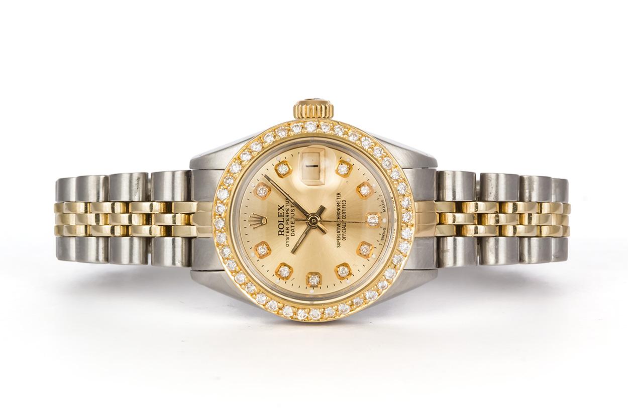 We are pleased to offer this 1980 Two Tone Stainless Steel & 18k Yellow Gold 26mm Ladies Rolex Oyster Perpetual Date 6917. It features a 26mm Rolex case, aftermarket diamond dial & 18k yellow gold & diamond bezel, stainless steel & 18k yellow gold