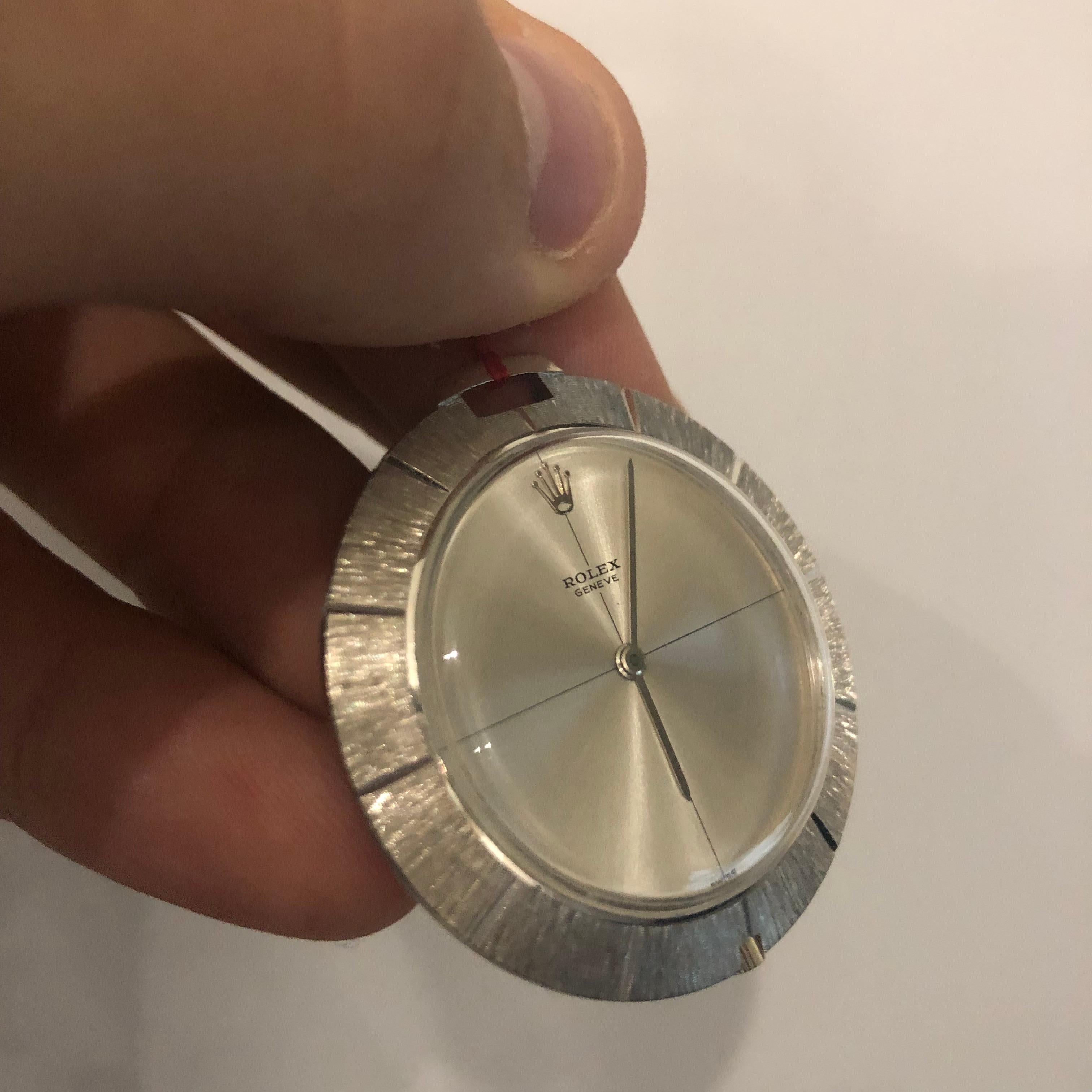 An 18k White Gold Vintage Disk Pendant Watch from 1966, zephyr silver dial, a fixed 18k white gold patterned bezel, an 18k white gold pendent bale where a chain can be attached so the piece can also be worn, plastic glass, manual wind movement, in