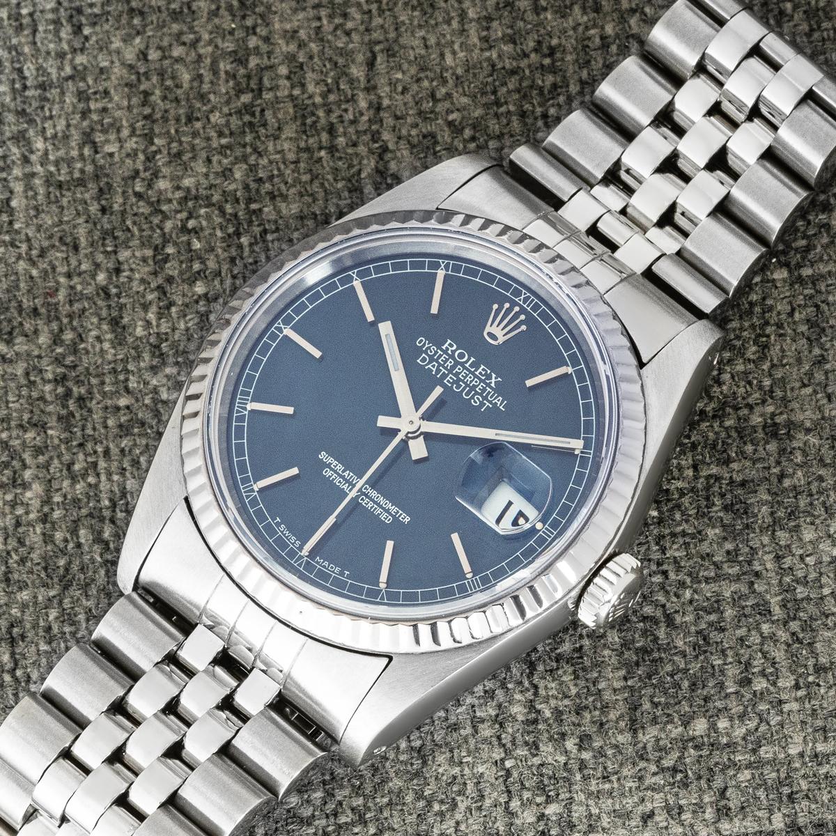 Un reloj de pulsera Rolex Datejust, disponible ahora en nuestra sala de exposiciones de Londres.

Fabricado en acero inoxidable, este reloj de caballero muestra la hora en una esfera azul con índices aplicados. La esfera cuenta con una abertura para