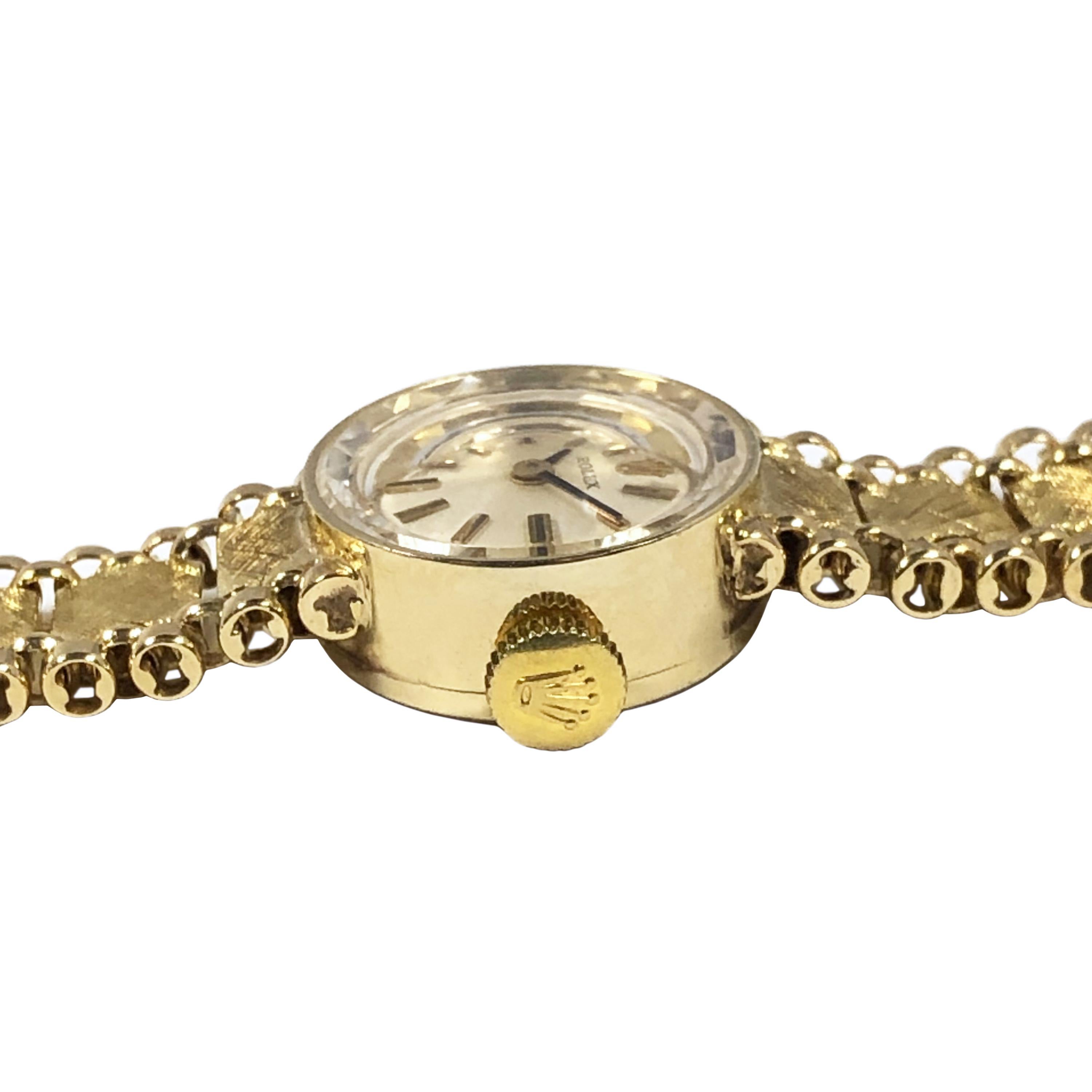 Circa 1980 Rolex Ladies Bracelet Wrist Watch, 25 M.M. 14k Yellow Gold 2 piece case, 17 Jewel mechanical, manual wind movement, Silver Satin Dial with raised Gold markers, Rolex logo Crown. 3/8 inch wide tapering 14k Yellow Gold link Bracelet with