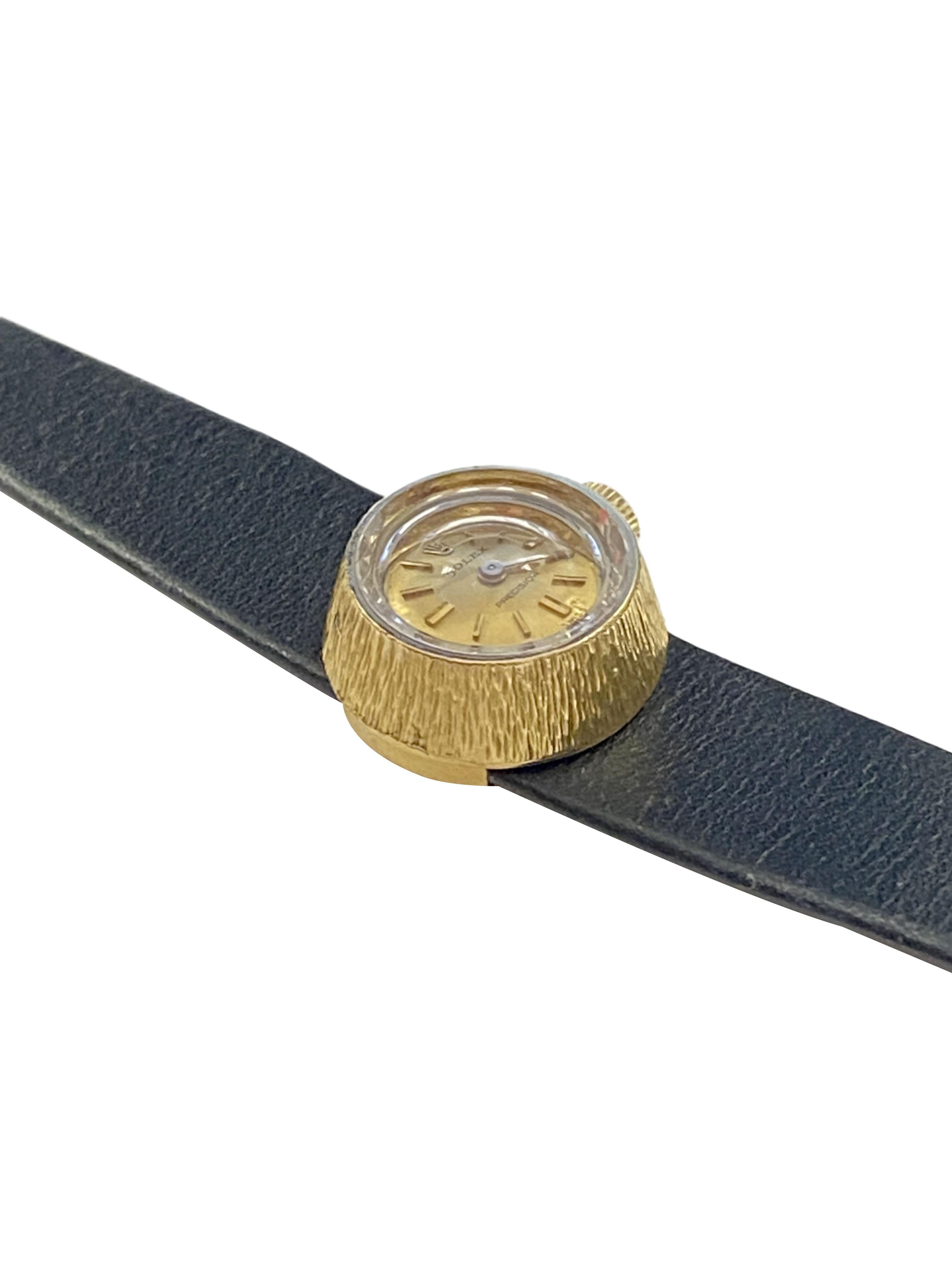 Circa 1960 Rolex Orchid Ladies Wrist Watch, 18k Yellow Gold 2 Piece textured case measuring  12 m.m. in Diameter and 8 M.M. thick. 17 Jewel Mechanical, manual wind movement, Gold dial with raised Gold markers. Original Black Leather pull through