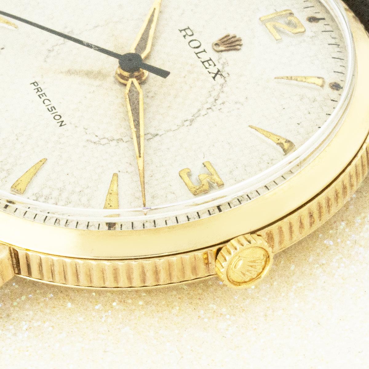 A rare vintage Rolex Precision in 9 carat yellow gold. Features a rare silver honeycomb dial with Arabic numerals at every quarter and luminus hands housed in a 9ct yellow gold 34mm coin-edge case. This piece is fitted with plastic glass, a manual