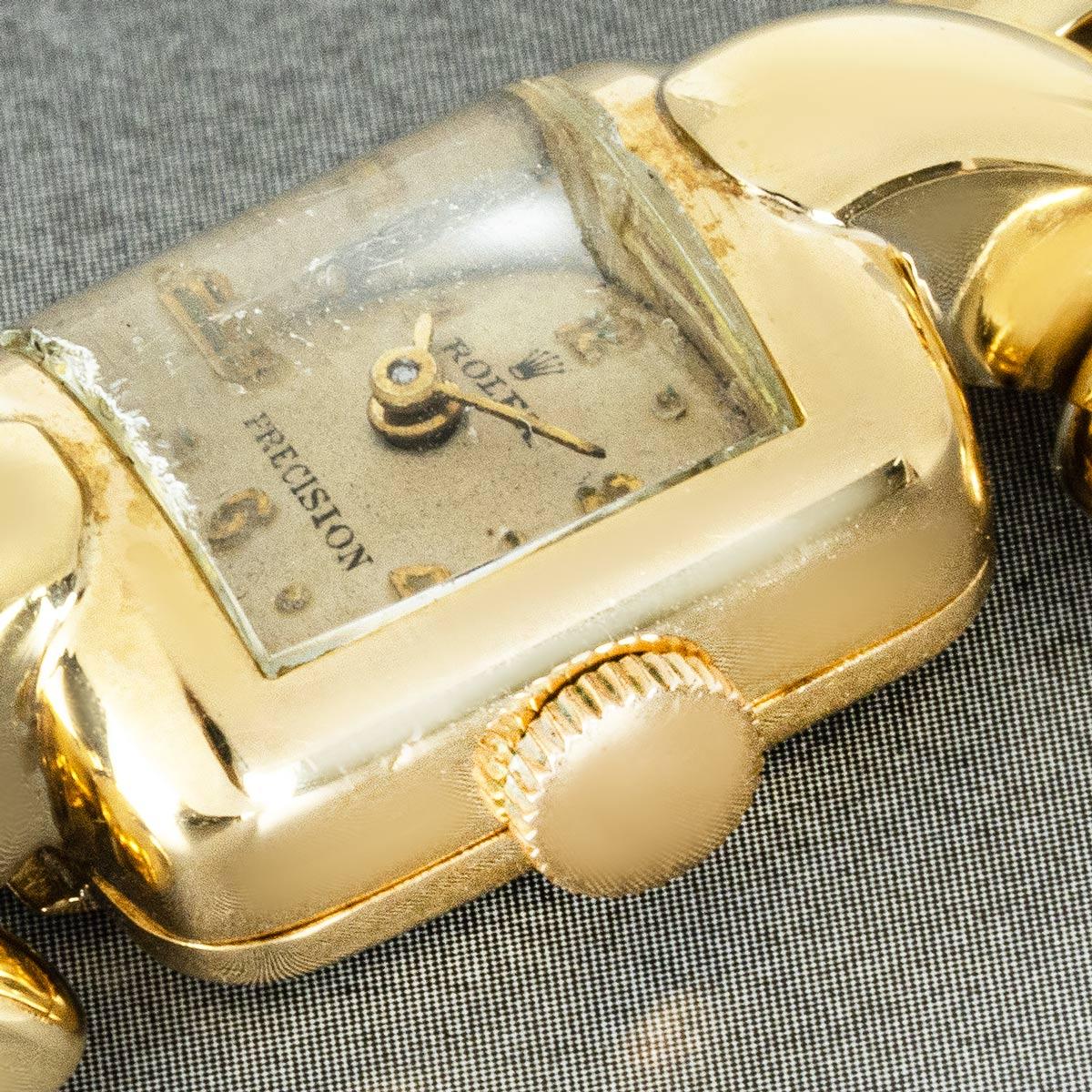 <p>This timeless Rolex Precision wristwatch is crafted in elegant yellow gold, showcasing an aged silver dial with applied arabic hour markers. The watch is paired with a matching yellow gold link bracelet secured by a jewellery-type clasp and