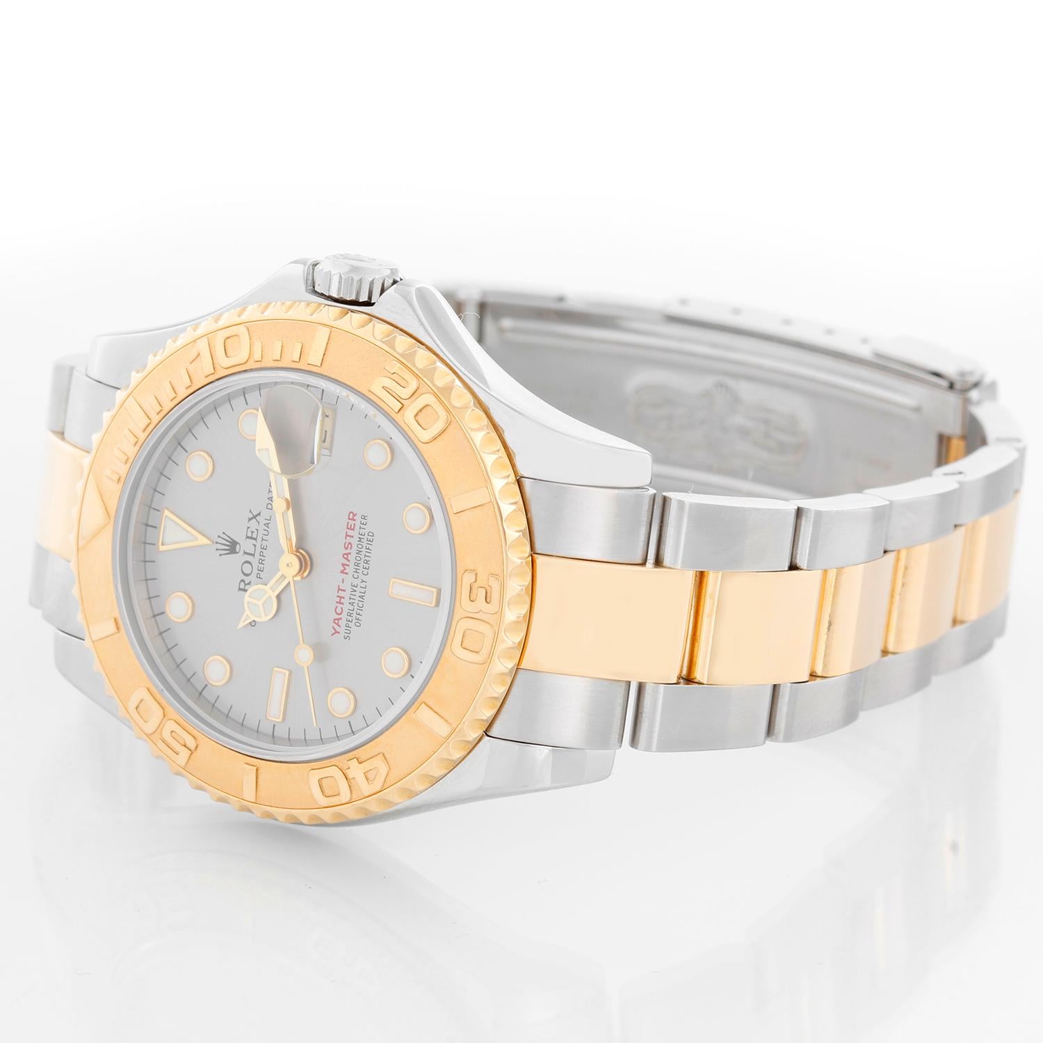 Rolex Yacht-Master Midsize  Men's/Ladies Steel & Gold 2 Tone Watch 68623 - Automatic winding, 31 jewels, Quickset, sapphire crystal. Stainless steel case with 18k yellow gold rotating bezel (35mm diameter). Silver dial with luminous style markers.