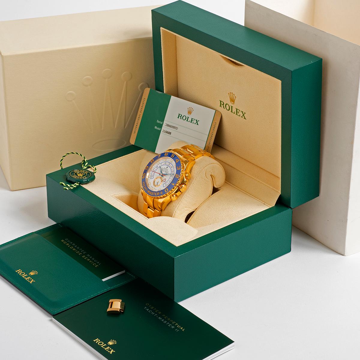 Our rare, discontinued and very desirable Rolex Yachtmaster II reference 116688 features a 44mm 18k yellow gold case with 18k yellow gold bracelet, white dial and blue ceramic dial. This Yachtmaster II is presented in outstanding unpolished