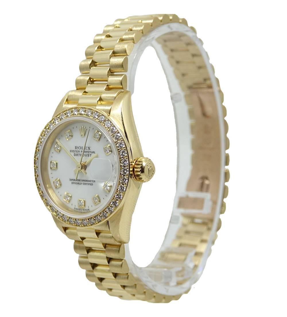 This Classic 18K Yellow Gold Ladies Rolex President Has A Original White Diamond Dial With Diamond Markers, Each Diamond Is F Color and VVS Clarity. This Rolex Has A 26mm Case With A Sparkling Diamond Bezel and Fits A Size 6.5 Inch Wrist. This Watch
