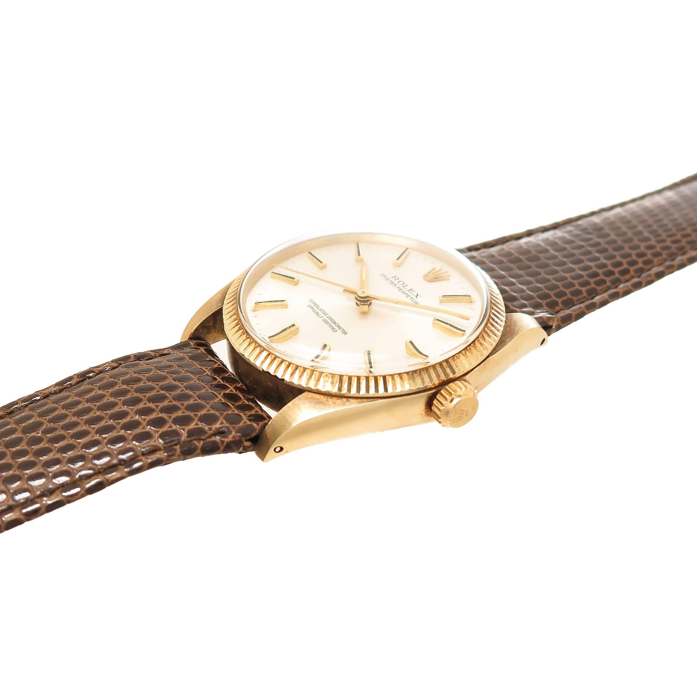 Circa 1974 Rolex Oyster Perpetual Wrist Watch, 34 M.M. 14K Yellow Gold Oyster Case with Fluted Bezel. 26 Jewel Automatic, Self winding Movement, Silver dial with raised Gold markers and a sweep seconds hand. Brown Lizard Strap with Gold Plate Rolex