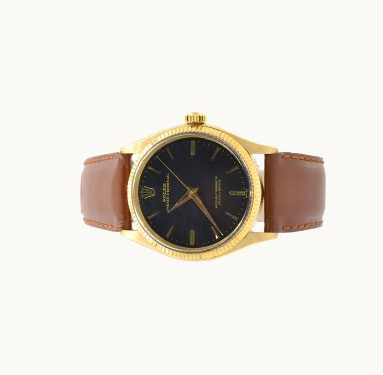 A classic Rolex Oyster Perpetual wristwatch in 18 karat yellow gold, reference 1005. This beautiful Rolex features an 18 karat yellow gold oyster case, an 18 karat yellow gold fluted bezel, plastic crystal, black original dial with gold stick