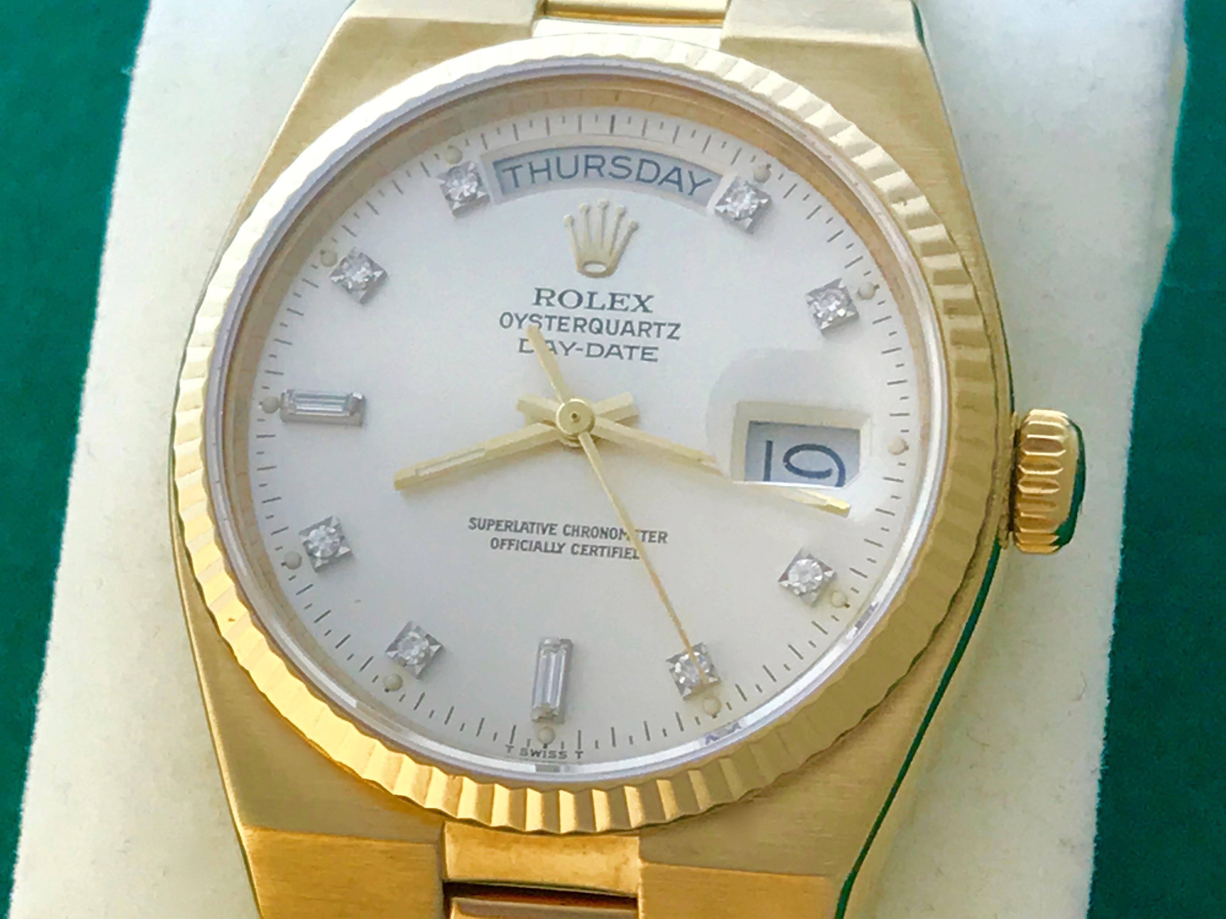 Rolex President Day-Date Model 19018 Pre Owned Mens Quartz wrist watch. Oyster Silver Dial with Rolex Diamond hour markers. 18k Yellow Gold case with fluted bezel (35mm). 18k Yellow Gold hidden clasp President bracelet. Rolex box and instruction