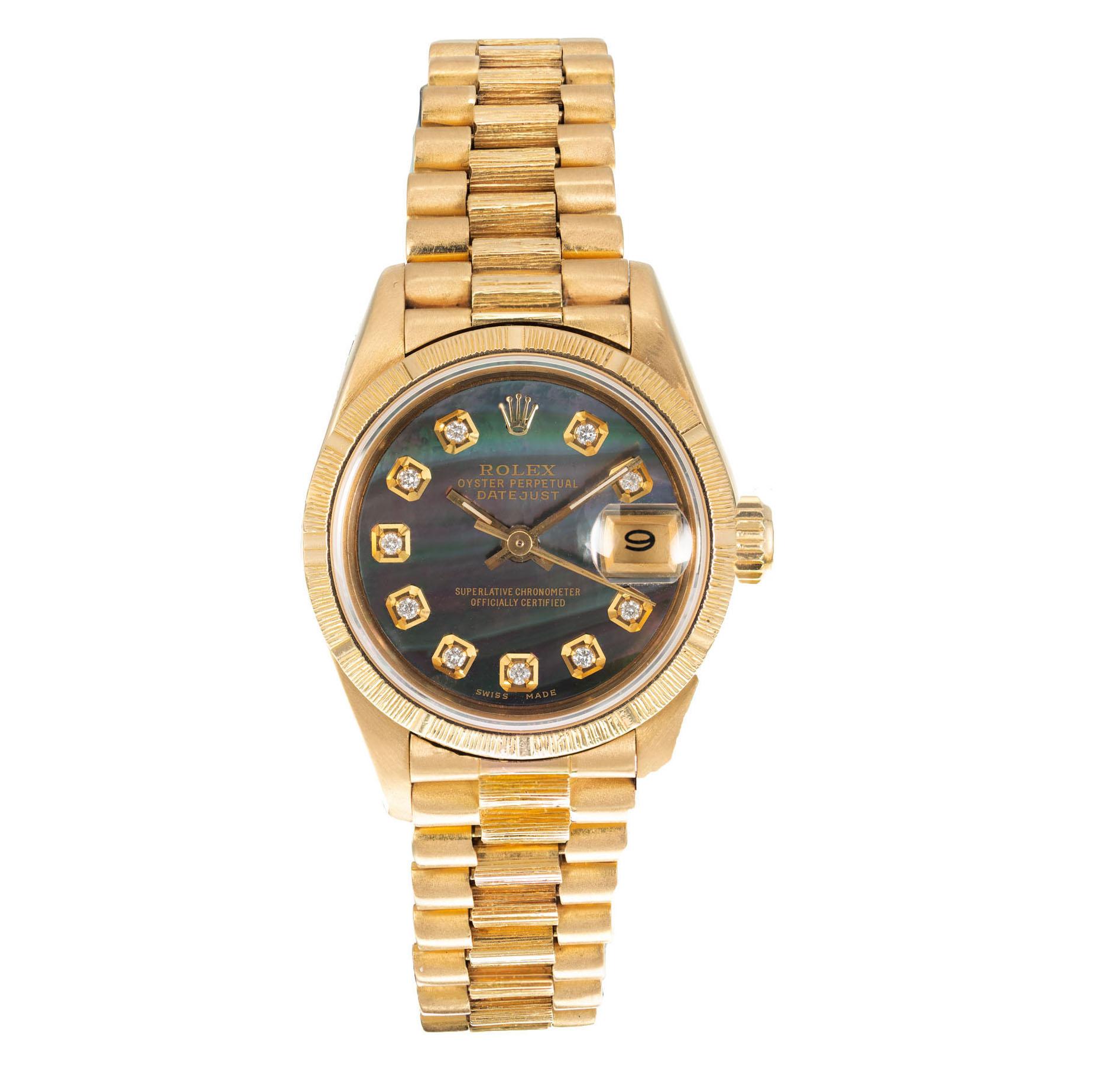 Ladies Rolex bark finish President wristwatch in solid 18k gold with a custom black mother of pearl diamond dial. 7 Inches. Circa 1985

Length: 33.05mm
Width: 26mm
Band width at case: 13.50mm
Case thickness: 10.46mm
Band: 18k yellow gold
Crystal: